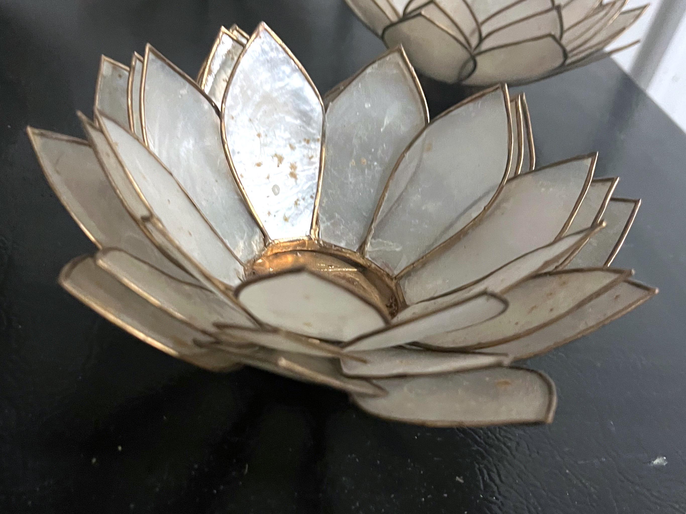 These pretty lotus form tea light candle holders are just so pretty. They are made of capiz shell and a gold tone metal. This is a set of 5.
