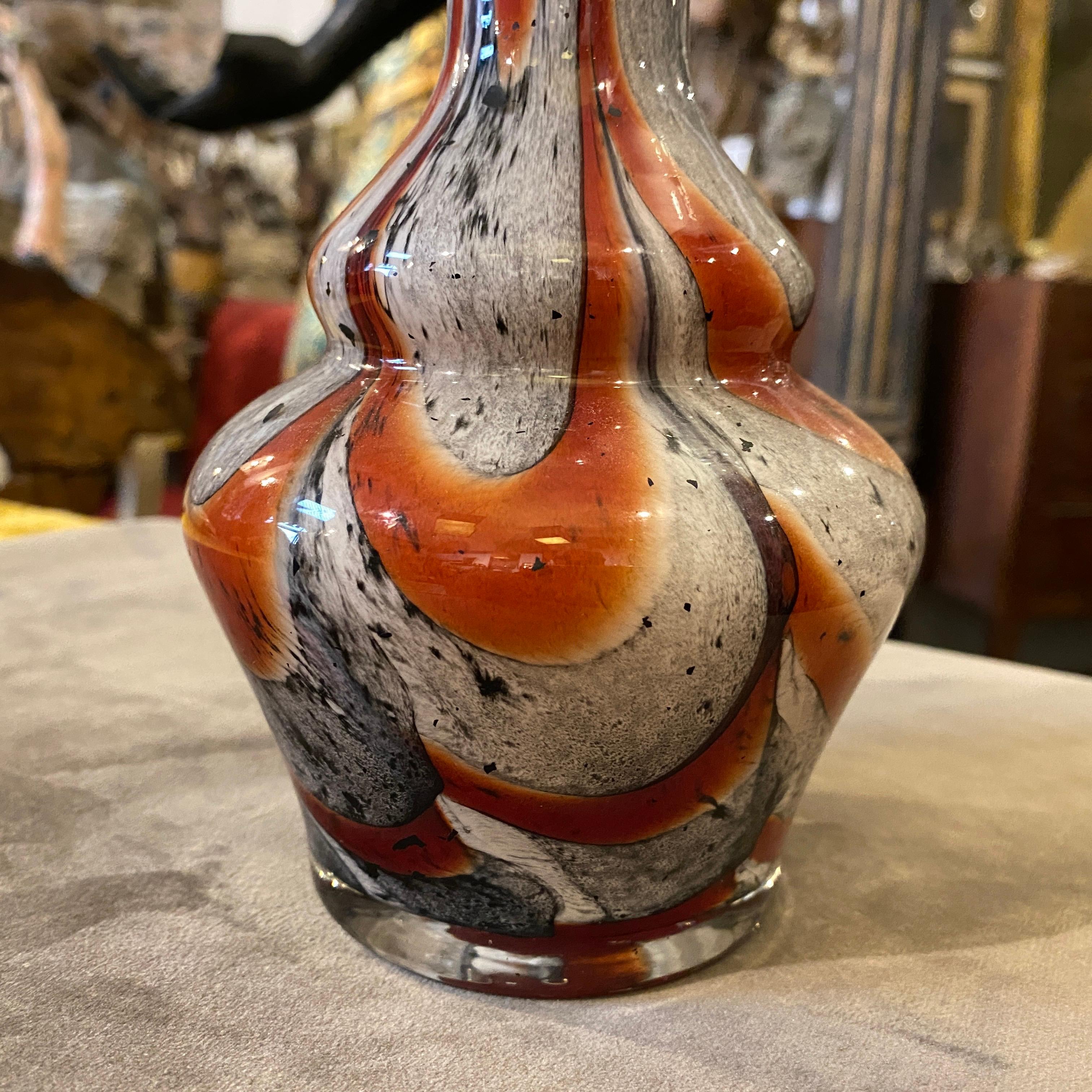 A stylish vase designed by Carlo Moretti and manufactured by Opaline Florence in the Seventies, the red, orange and gray decors on a white opaline glass are in perfect conditions. This  Vase is a beautiful and unique piece of vintage glassware.