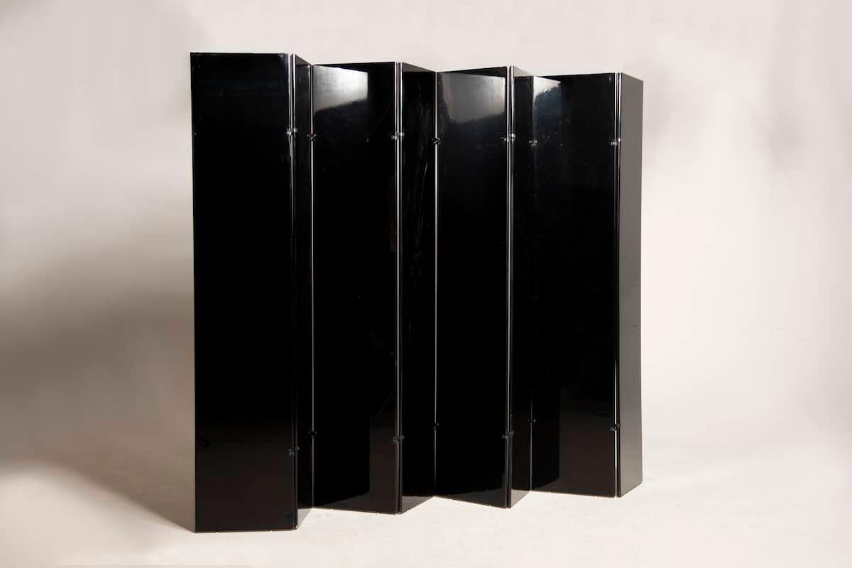 Glossy black polyester lacquered screen by Carlo Scarpa from the 1970s. 

The screen is divided into 8 doors 40cm wide and is lacquered equally on both sides. It features black finish details, the feet are steel and are very small in size so that