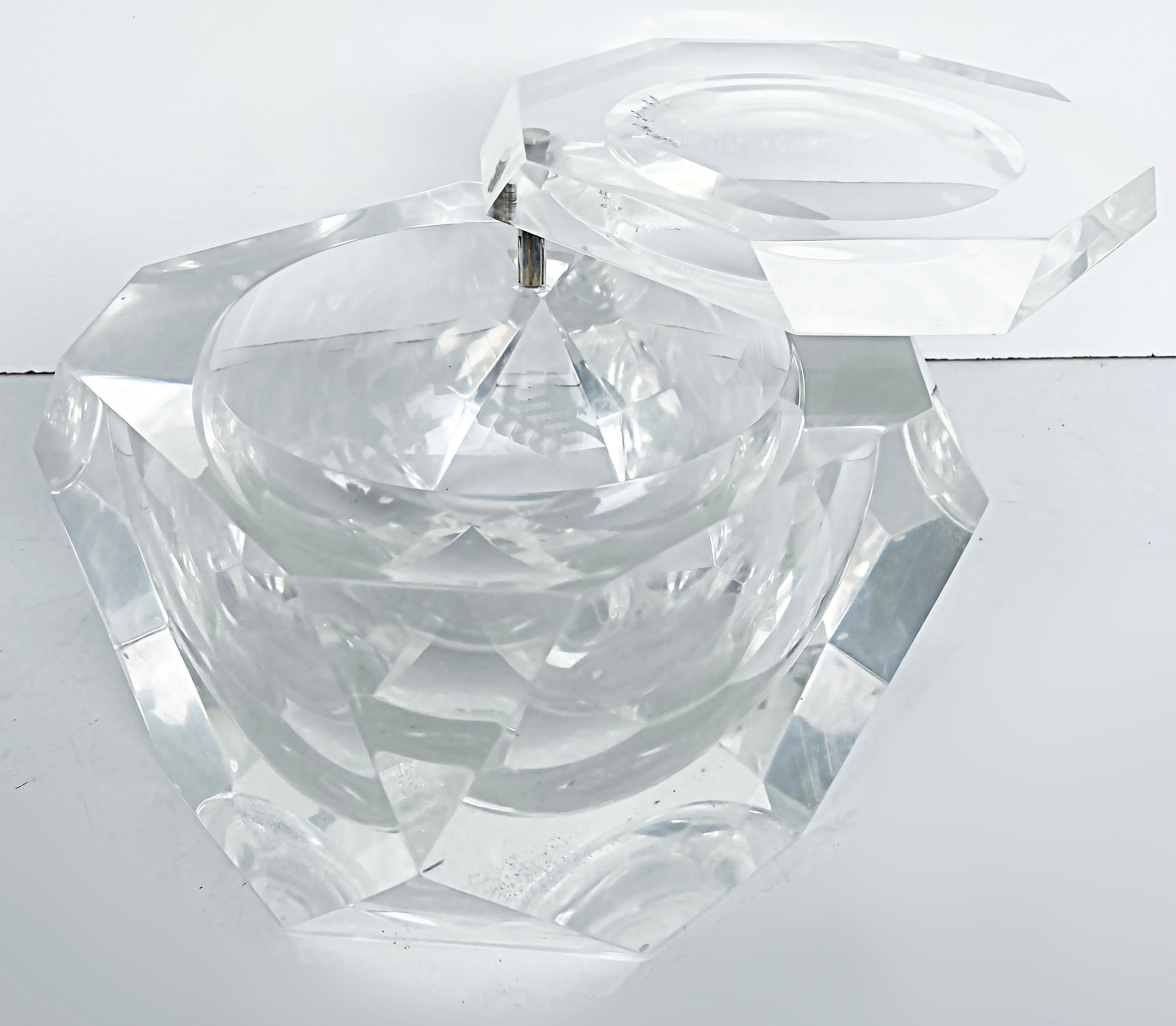 1970s Carole Stupell Faceted Swivel Top Lucite Ice Bucket, Octagonal

This elegant Mid-Century Modern octagonal ice bucket was created by the designer Carol Stupell, circa 1970. It features a faceted body and top composed of faceted translucent