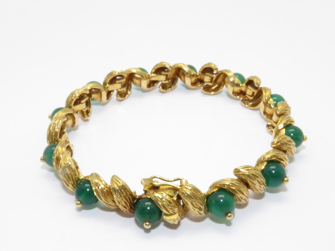 An 18K yellow gold link bracelet set with Green Agate.
Crafted by Cartier , the bracelet measures 18 cm long , 1 cm wide.
The weight of the piece is 36.6 grams.
Marked: Cartier Paris and Numbered
French Mark
Circa 1970