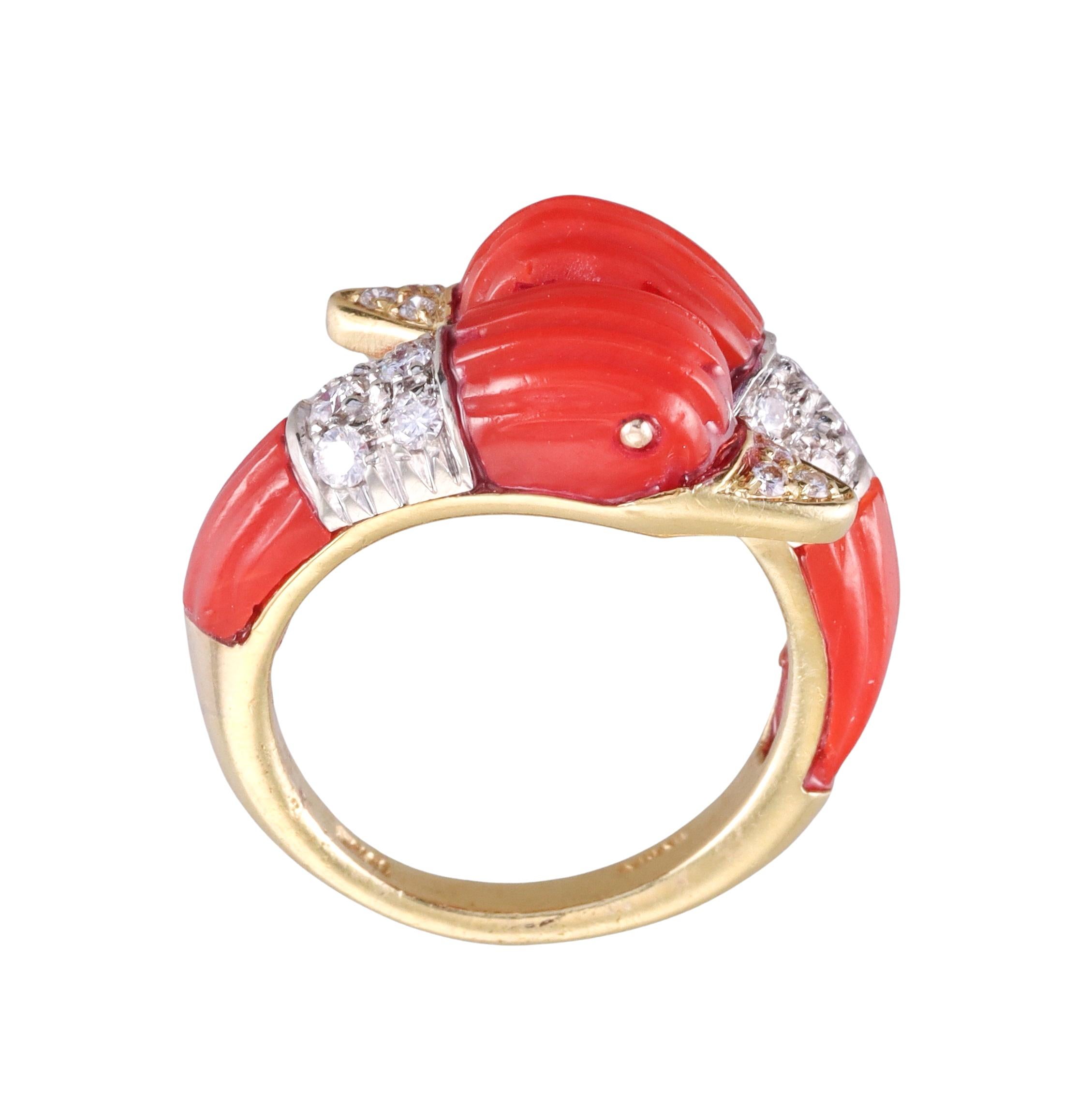 Délicate bague à pont en or 18k, vers les années 1970, présentant deux têtes de cygne qui se chevauchent. Décorée de corail sculpté et d'environ 0,40ctw de diamants SI/H. Bague de taille 6.5, le haut de la bague fait 15 mm de large. Poids de la