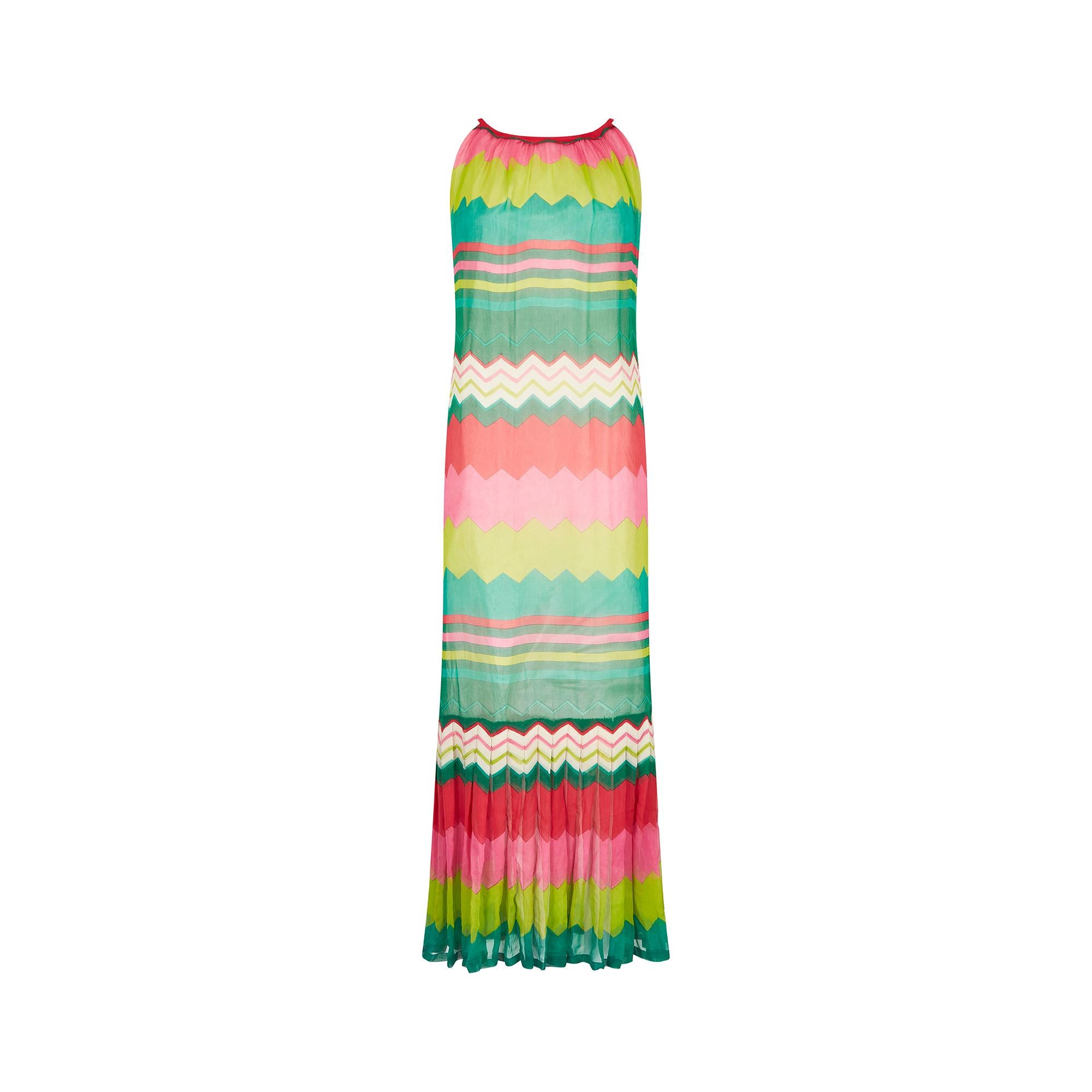 This colourful 1970s Carven haute couture maxi dress has a high rounded neckline with short shoulder straps and flows down into a sophisticated A-line shape to the ankles. The material is a lightweight silk chiffon in an alternating chevron and