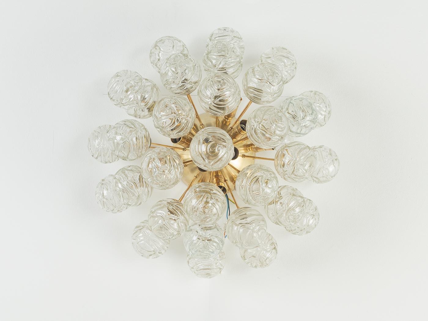 Lámpara de techo sputnik clásica de los años 70, de Doria Leuchten, con globos de cristal decorativos. La estructura colgante es de latón con 12 enchufes (toma E14).

Características de calidad:

    muy buena mano de obra
    materiales de alta