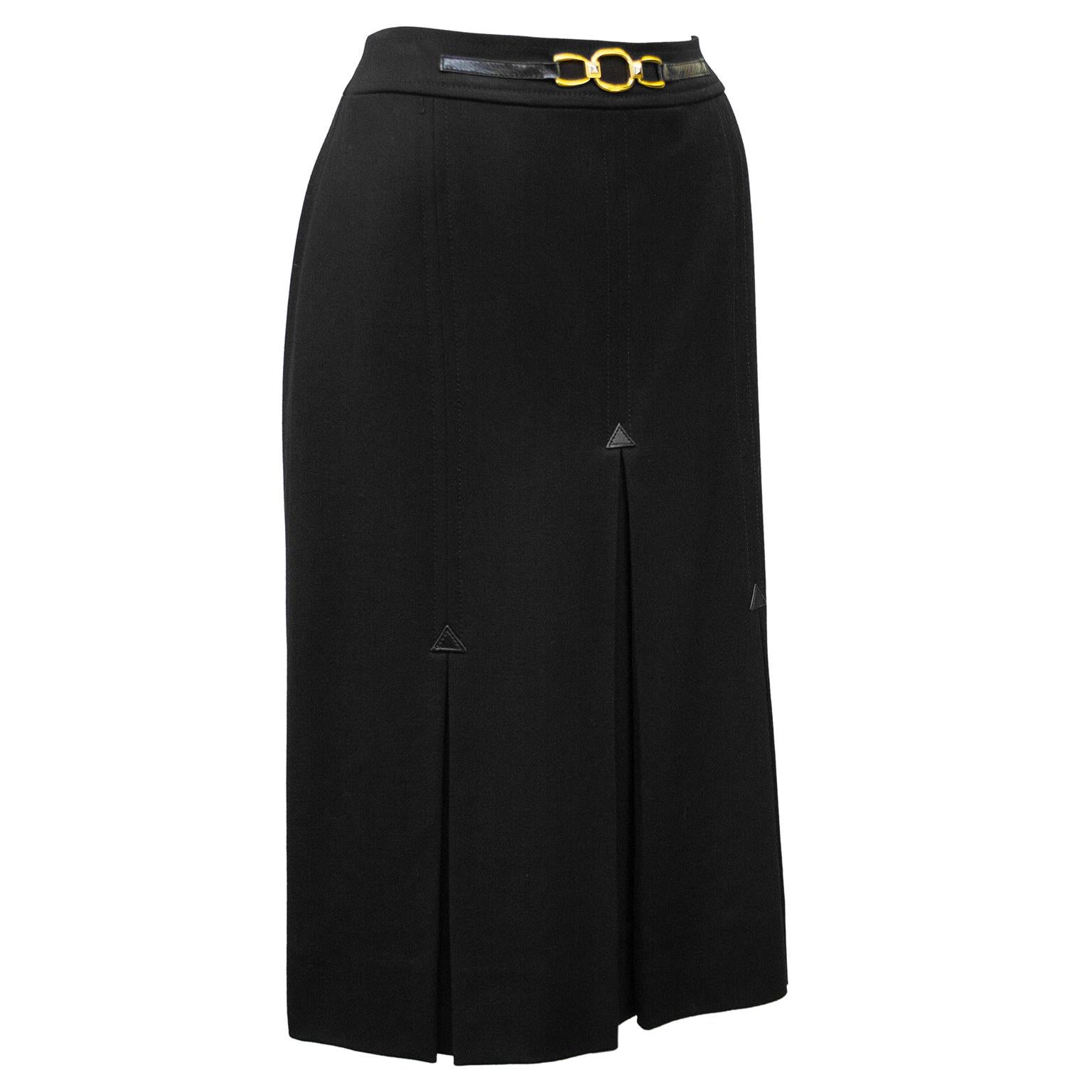 1970's classic Celine black wool gabardine skirt with half black leather and gold belt at waistband. Three inverted stitched box pleats on the front and back with small leather triangle detail. Overall A line shape. In excellent condition, side