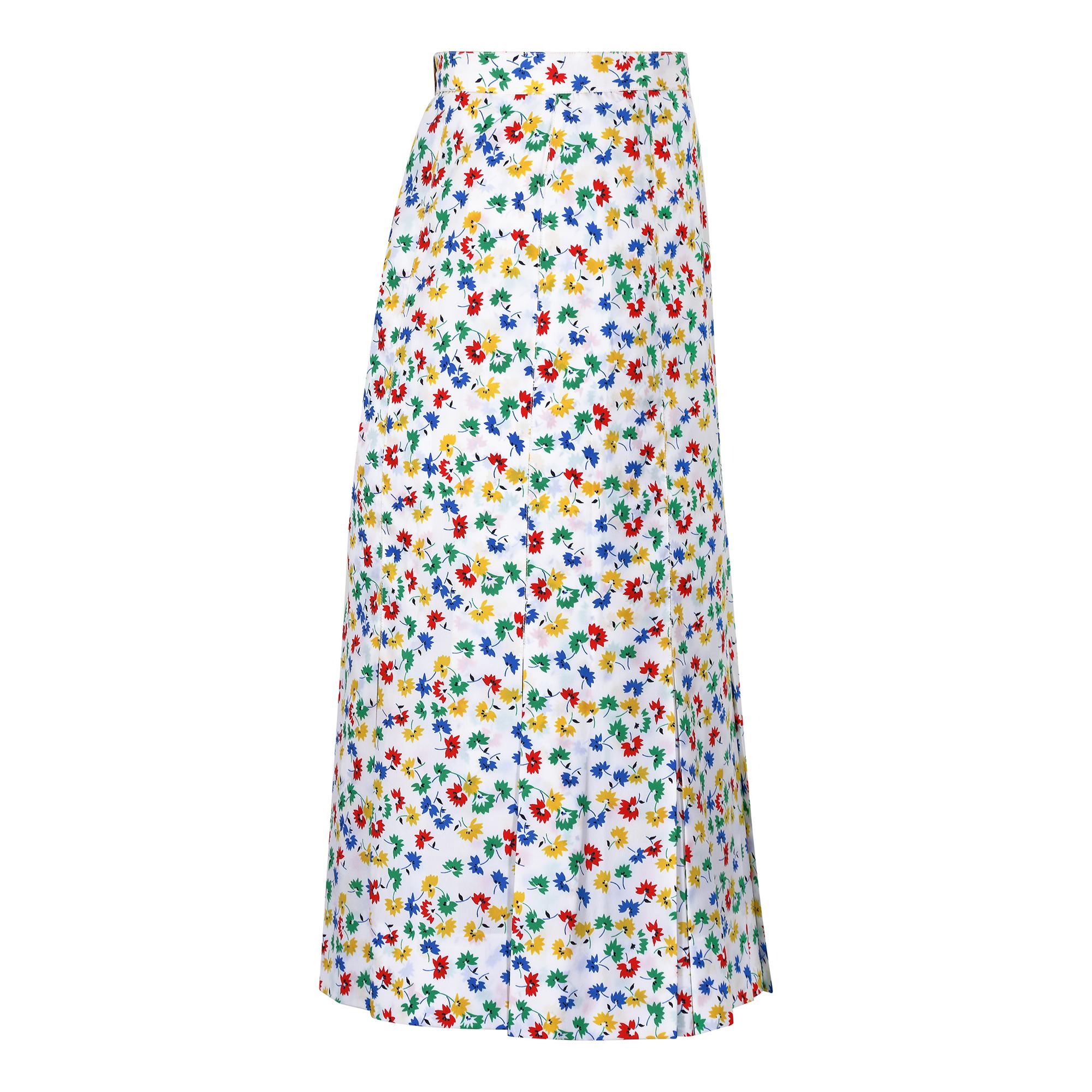 This 1970s or early 1980s Celine skirt has a very striking primary colour floral repeat print. The three-quarter length straight panelled skirt has for the remaining quarter, kick pleats forming the bottom hem which excite movement when worn and add