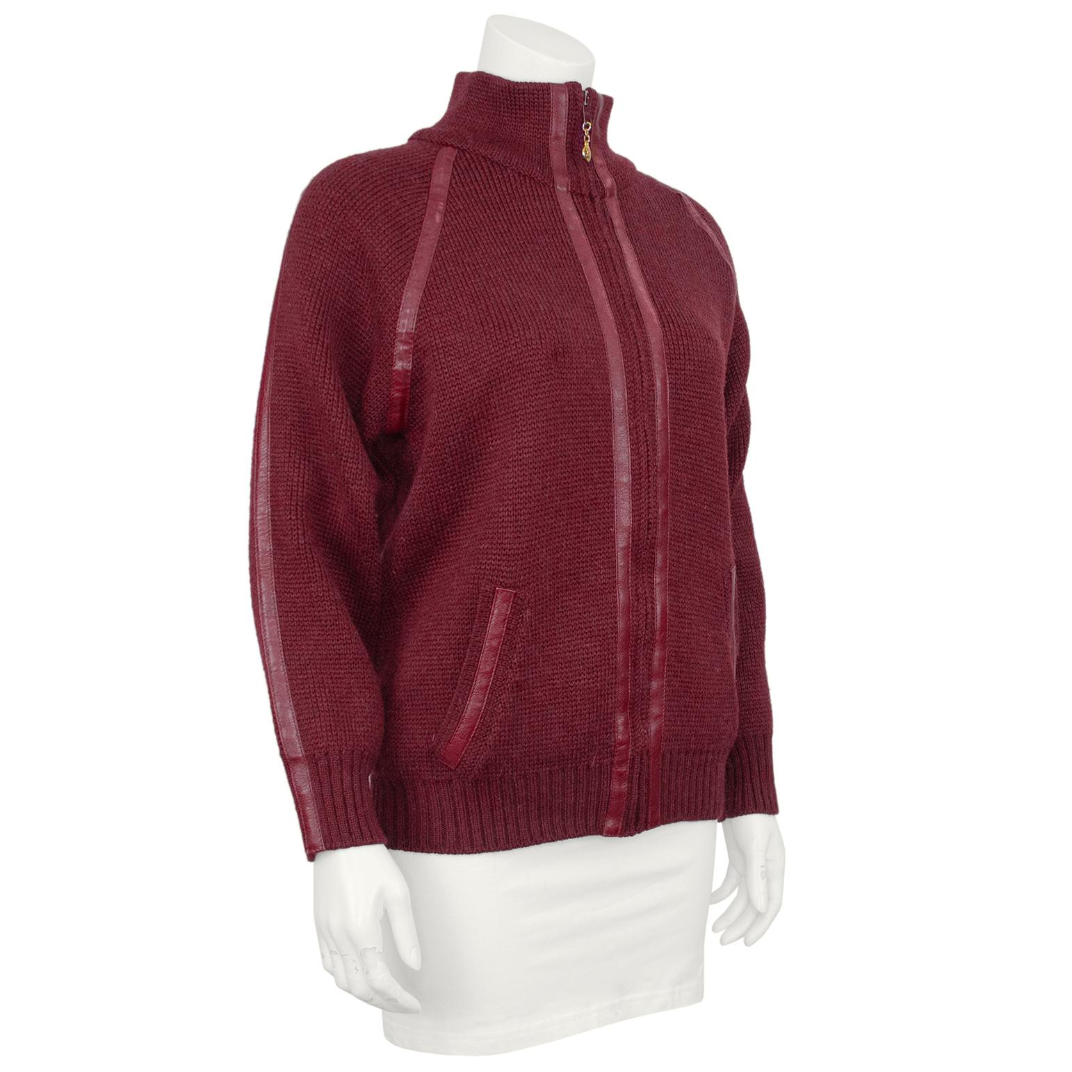 Celine zip up cardigan from the 1970s. Maroon knit wool with monochromatic leather trim throughout. High neck, loose through the body with ribbing at the hips and cuffs. Heavy weight wool, so this can be worn as a sweater or a light jacket. Gold