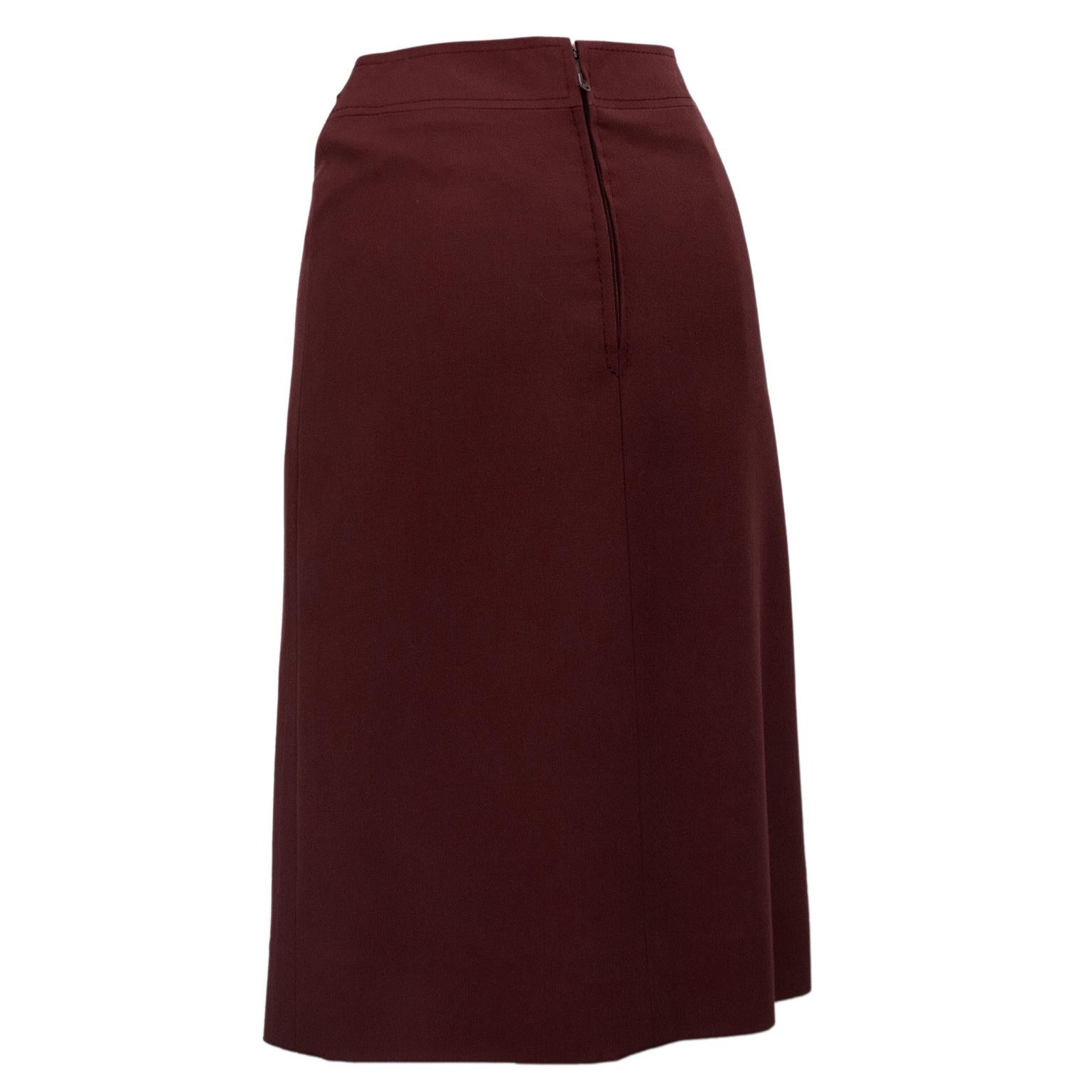 1970's classic Celine maroon wool gabardine wrap style skirt with pleating. Faux gold tone and leather maroon buckle at left hip. Overall A line shape. In excellent condition, side zipper with hook and eye. Fits like a US size 2. Made in France.