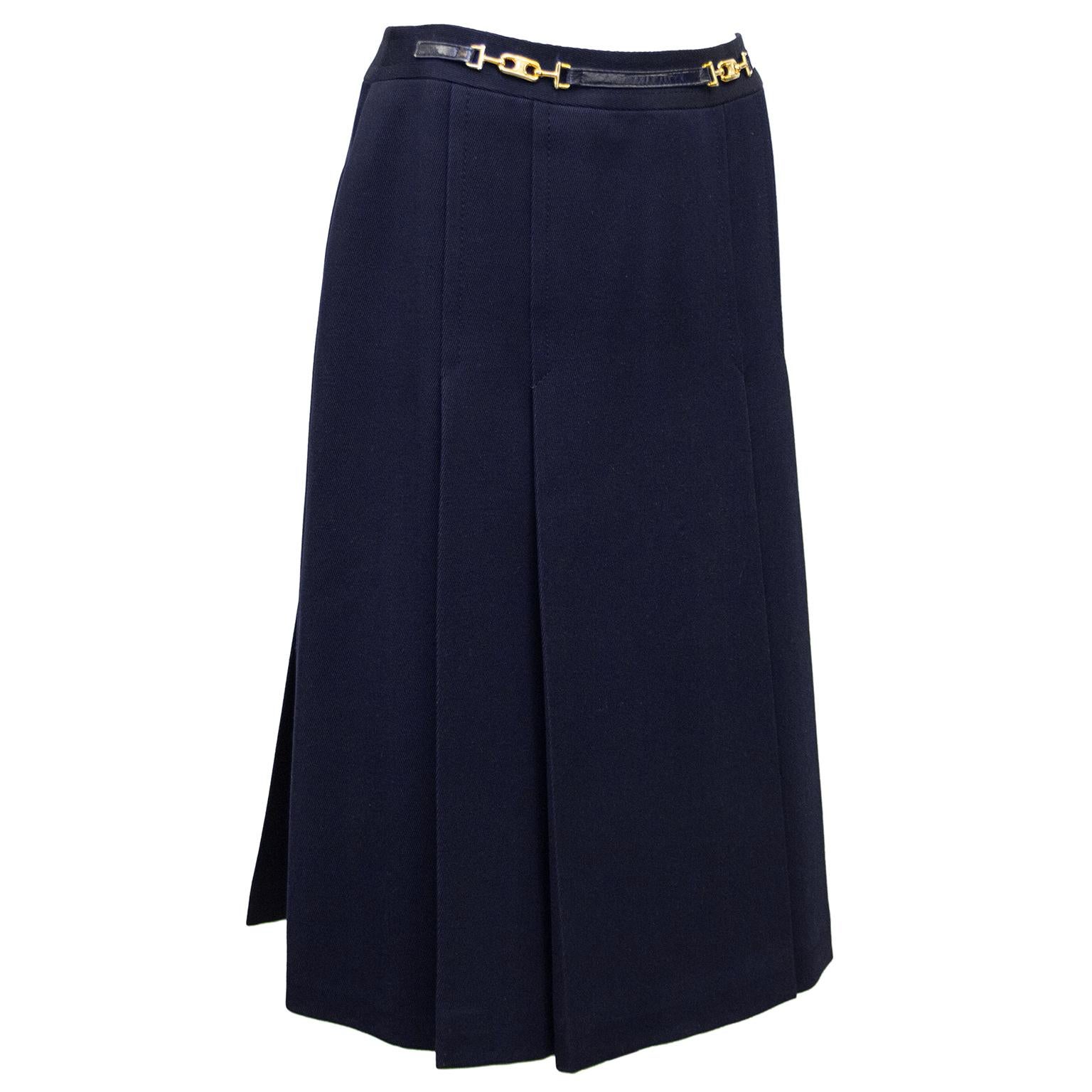 1970's classic Celine navy blue wool gabardine skirt with half navy leather and gold belt at waistband. Inverted stitched pleats on the front and back. Overall A line shape. In excellent condition, side zipper with hook and eye. Fits like a US size