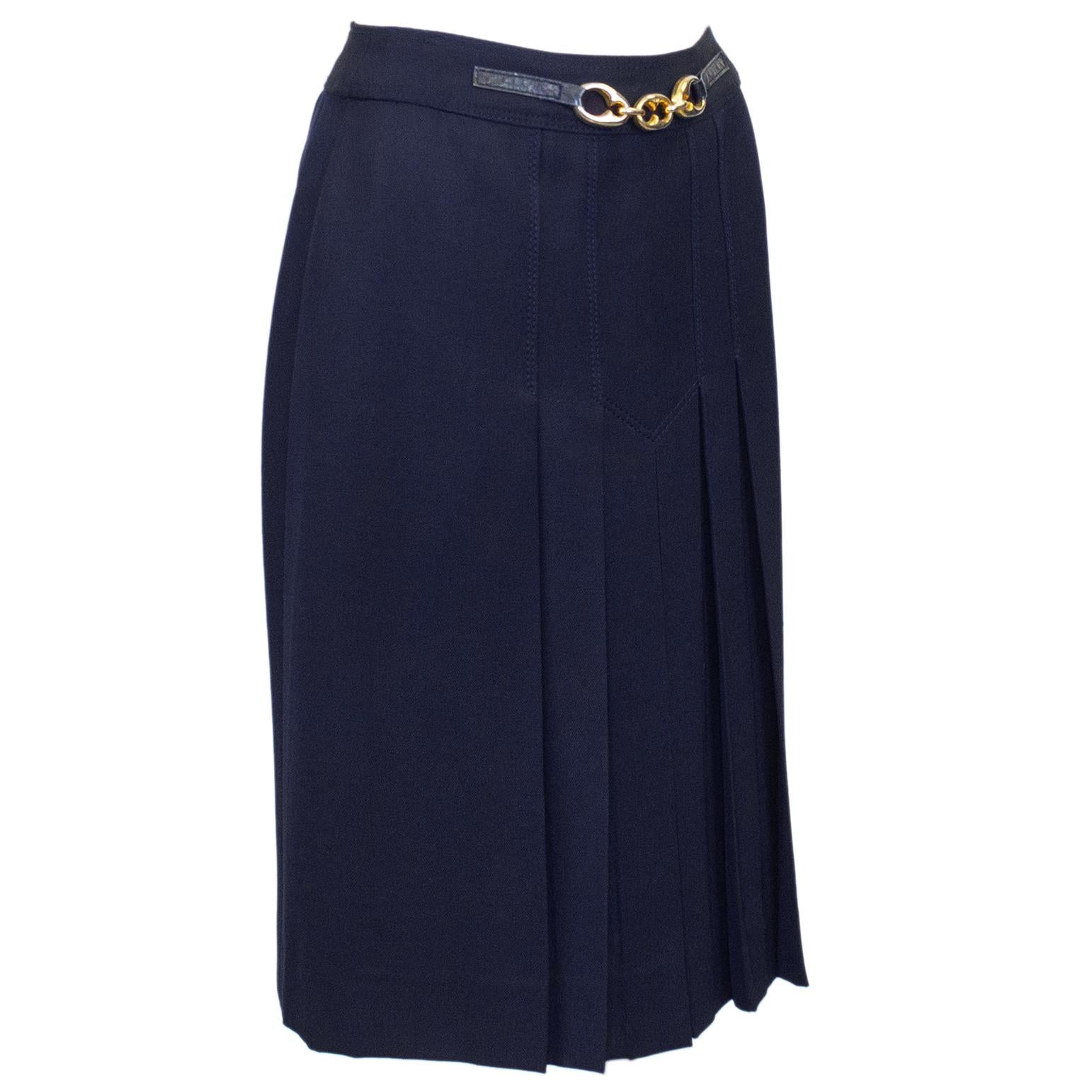 1970's classic Celine navy blue wool gabardine skirt with half navy leather and gold belt at waistband. Gold tone metal large mariner link detail at centre of belt. Inverted stitched pleats on the front and back. Overall A line shape.  Side zipper
