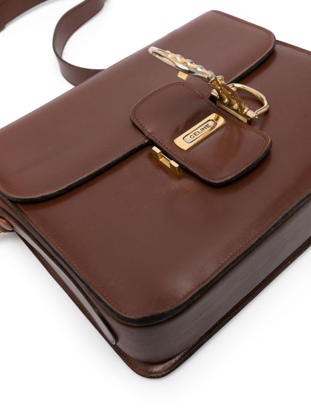 Celine nut box leather shoulder bag featuring gold-tone hardware, foldover top with front decorative closure, adjustable shoulder strap, partitioned compartment, internal slip pocket  and an inside gold-tone logo stamp. 
Circa: 1970's
Length: 7.9in.