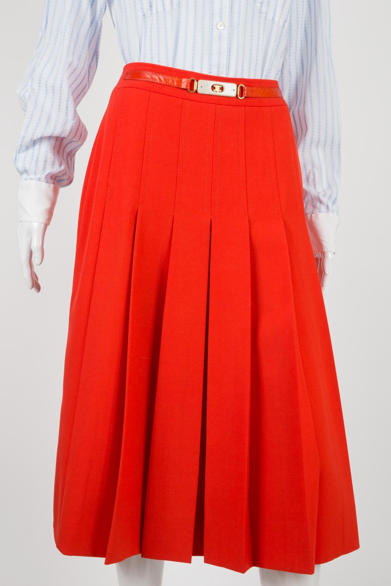 1970s Celine iconic red wool skirt featuring a front logo gold tone chain, a center back zip opening, a logo lining, front pleats. 
100% wool
Estimated size 36fr/ US4/ UK8
We guarantee you will receive this gorgeous item as described and showed on