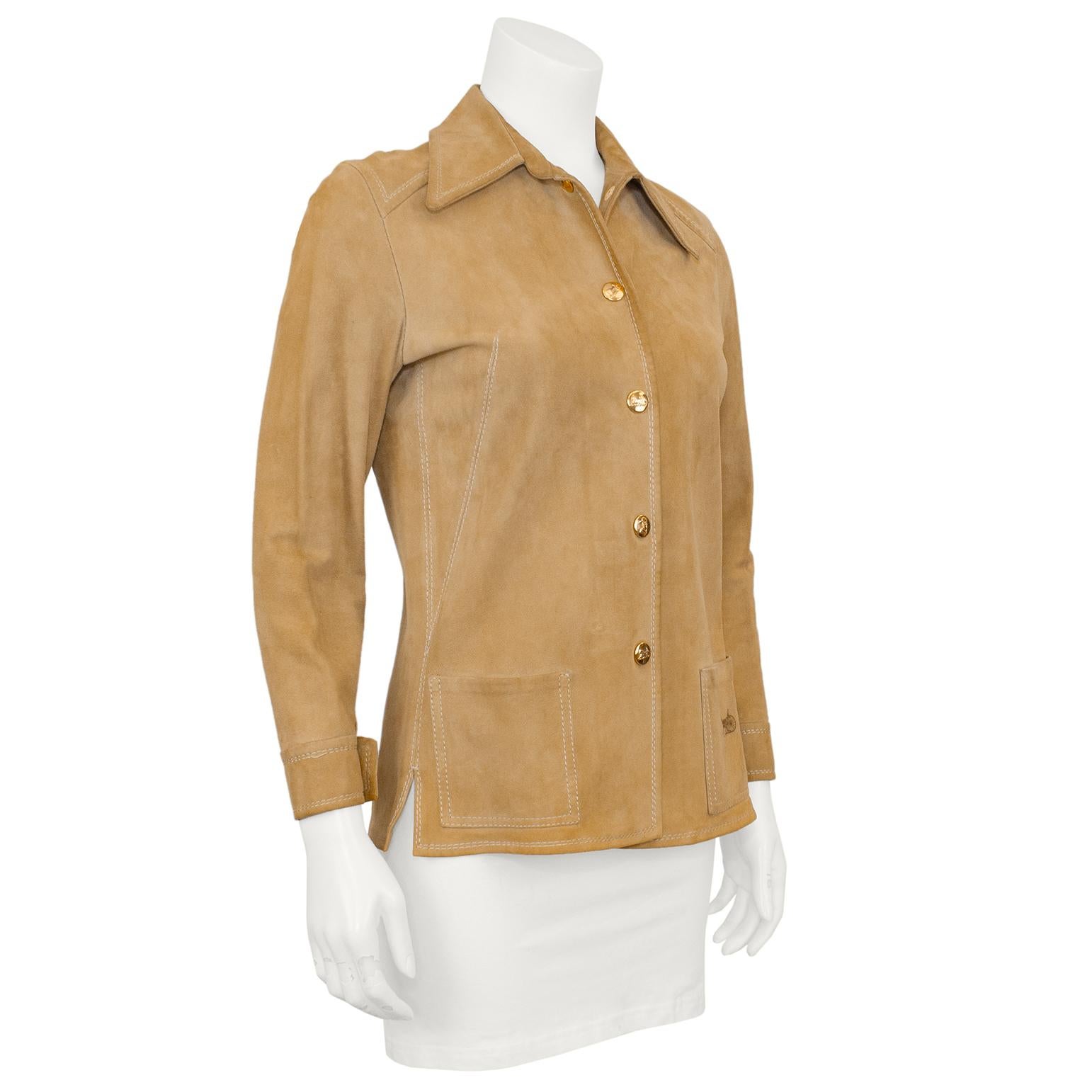 This is a quintessential 1970s piece! Celine tan suede lightweight jacket/shirt. Oversized very 70's collar with gold tone Celine logo buttons and white top stitching throughout. Patch pockets at hips with small slits at side seams. Left pocket when