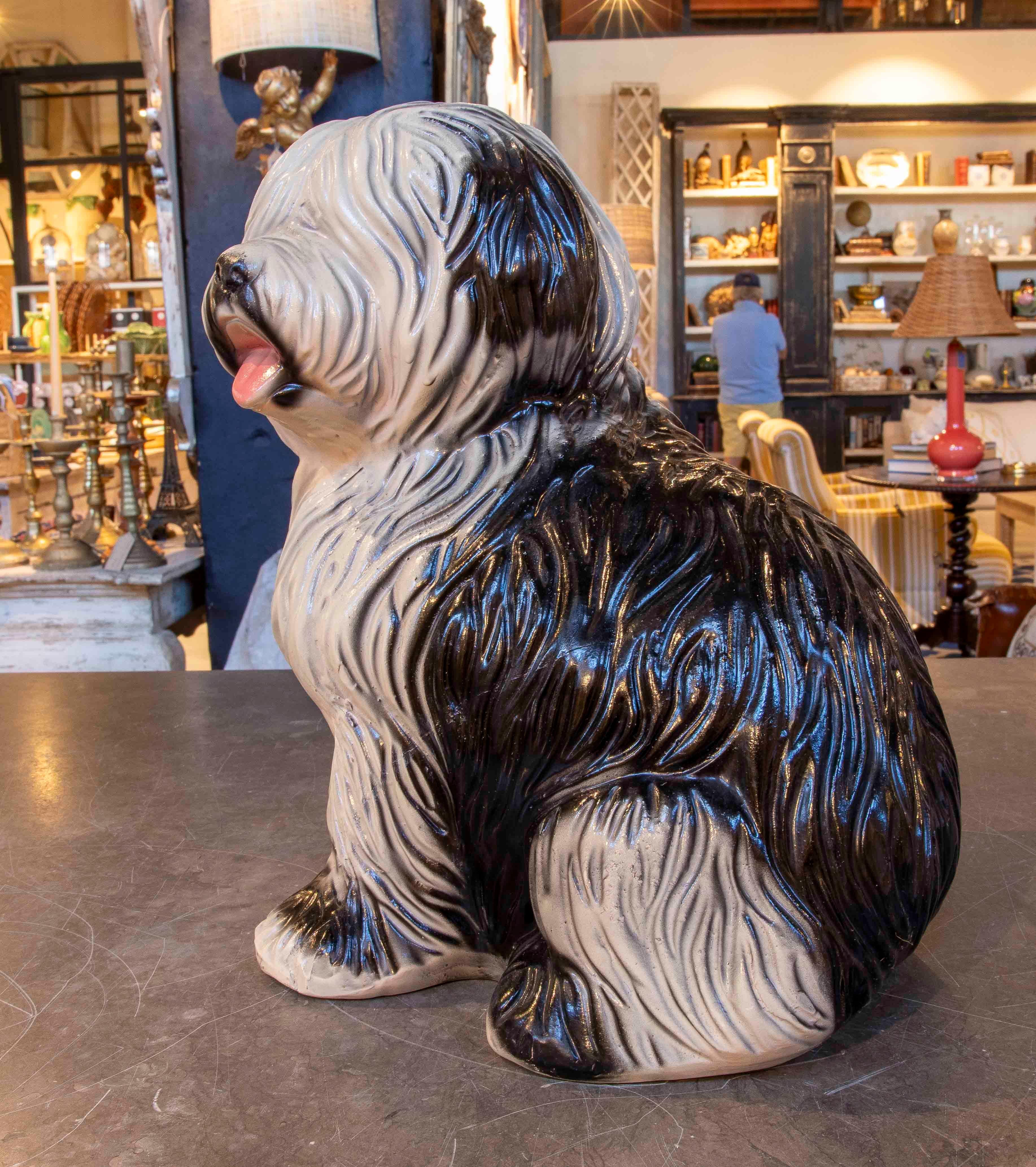 Elegant decorative figurine crafted from glazed ceramic depicting a sitting Shih Tzu. The piece stands out for its detailed black and white finish, with a texture that simulates the breed's characteristic coat. Its robust and expressive design,