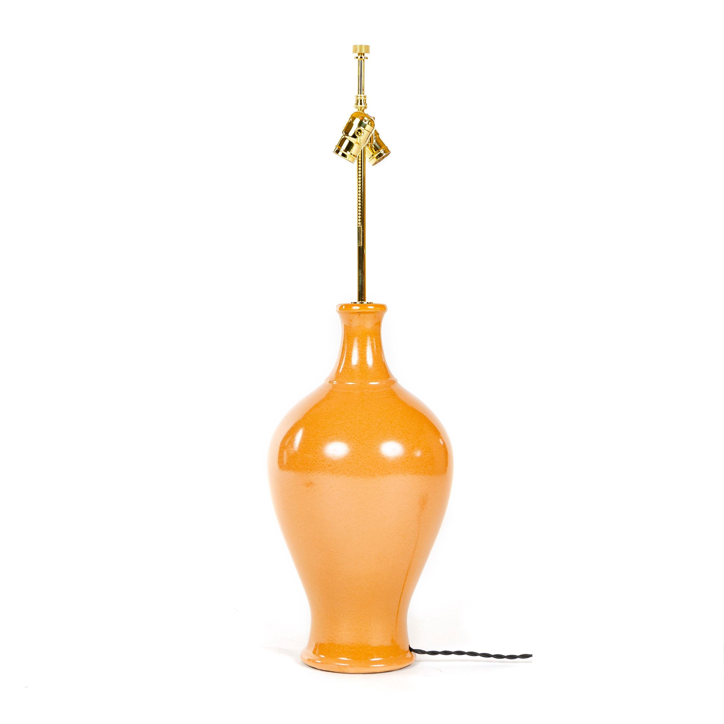 A classic, bulbous vase form rendered as a large curvaceous high glaze ceramic table lamp. Sold with an installed solid brass custom light fitting consisting of a circular cover plate for the rod hole, vertical rod, double socket ball cluster each