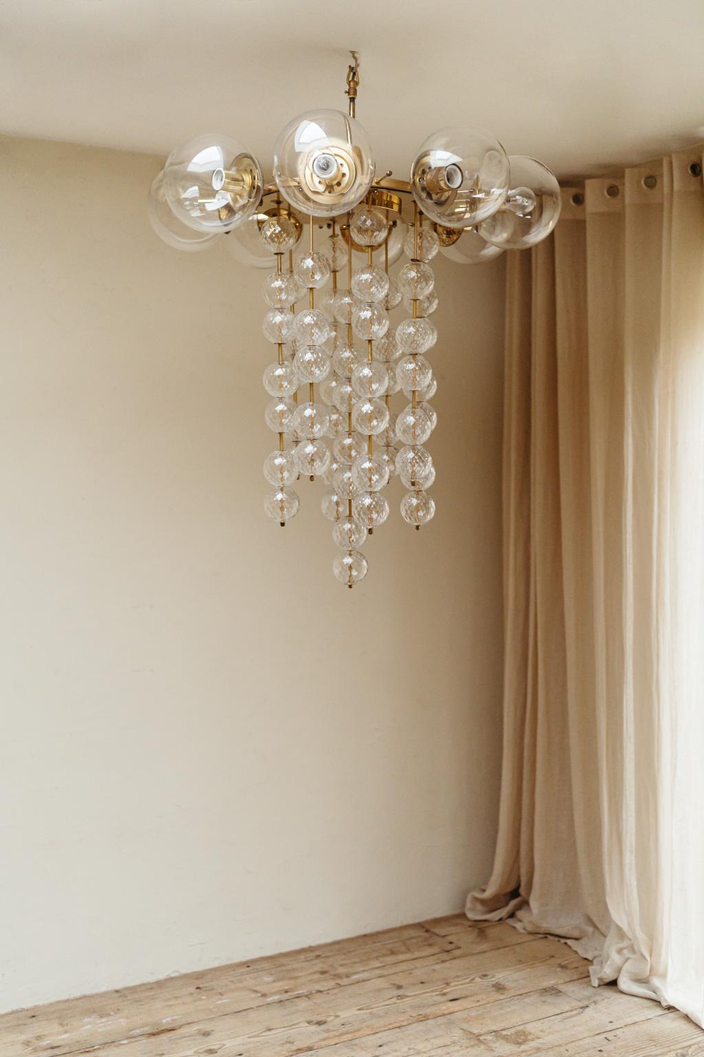 a waterfall of glass bulbs gives this 1970's chandelier a transparent and charming look.. in very good vintage condition .. 
