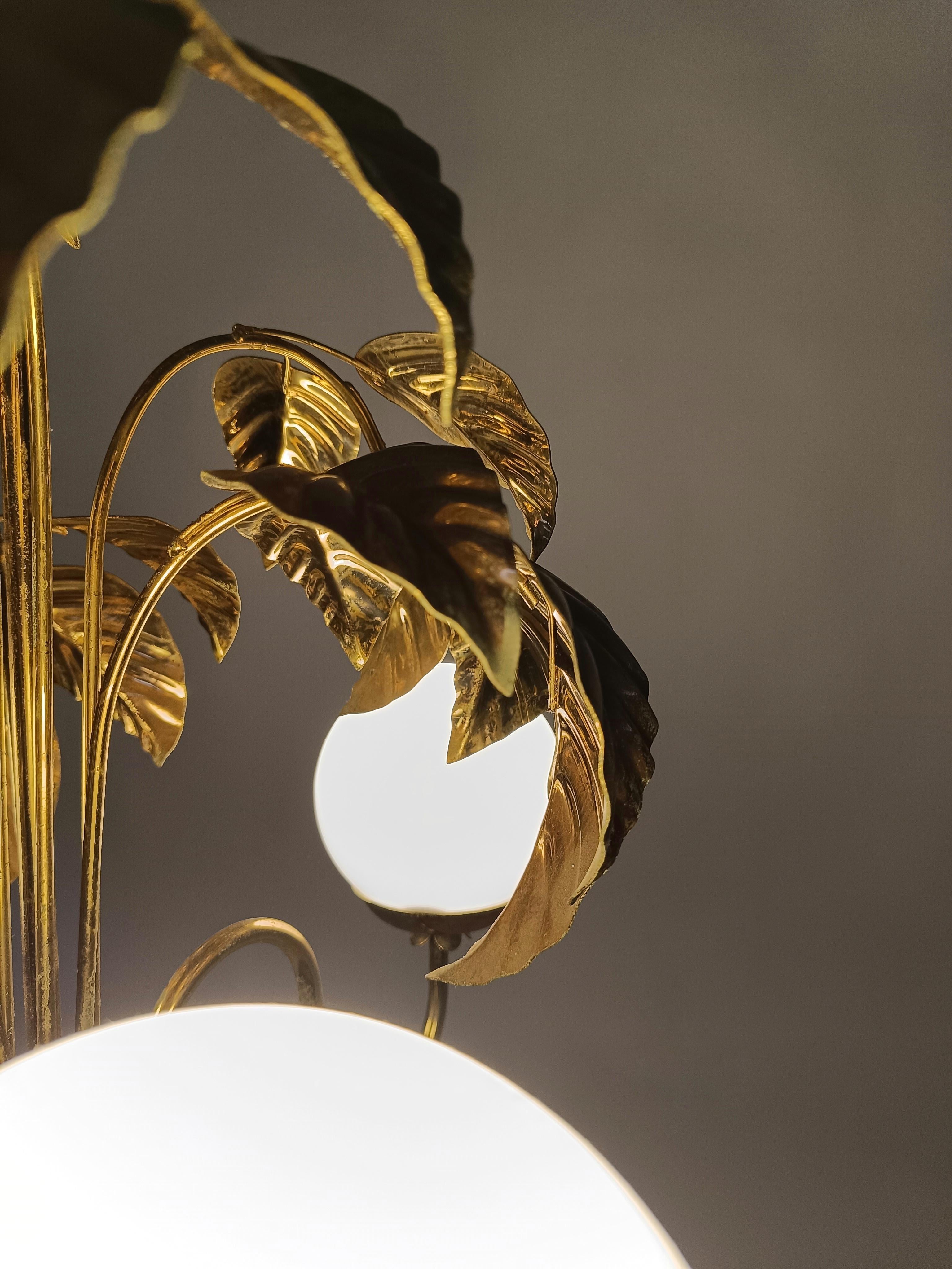 Una lámpara de araña fabricada en Italia entre los años 60 y 70, elegante y muy decorativa con su motivo de hojas que trepan por la pared como una planta de pothos.

El elemento decorativo frondoso y dorado tuvo un gran éxito durante los años 70,
