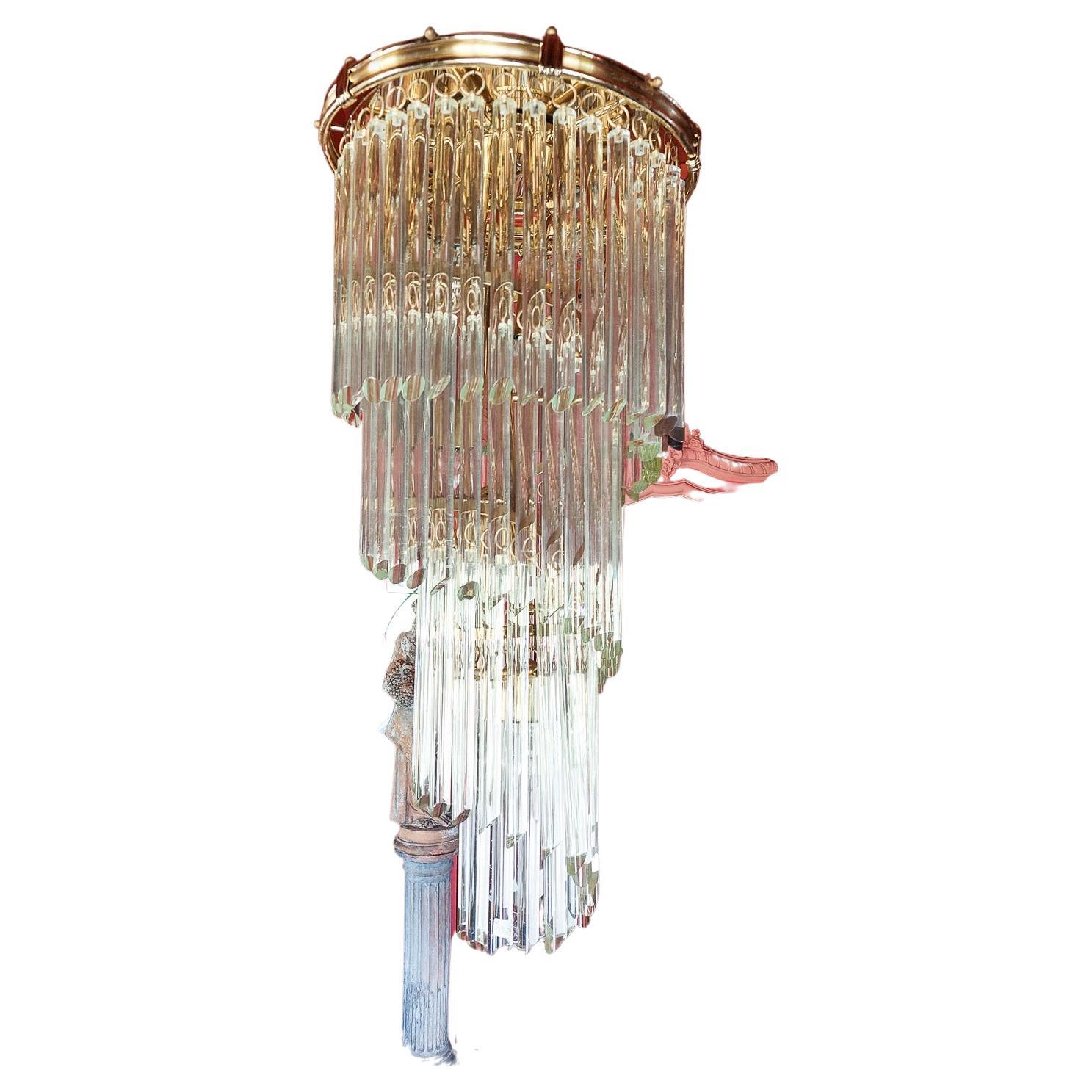 A stunning and sophisticated chandelier in the style of Venini with Murano glasses. The glasses are hung in a spiral row on a brass frame in a circular design. 

The height excluding the brass hanging 
