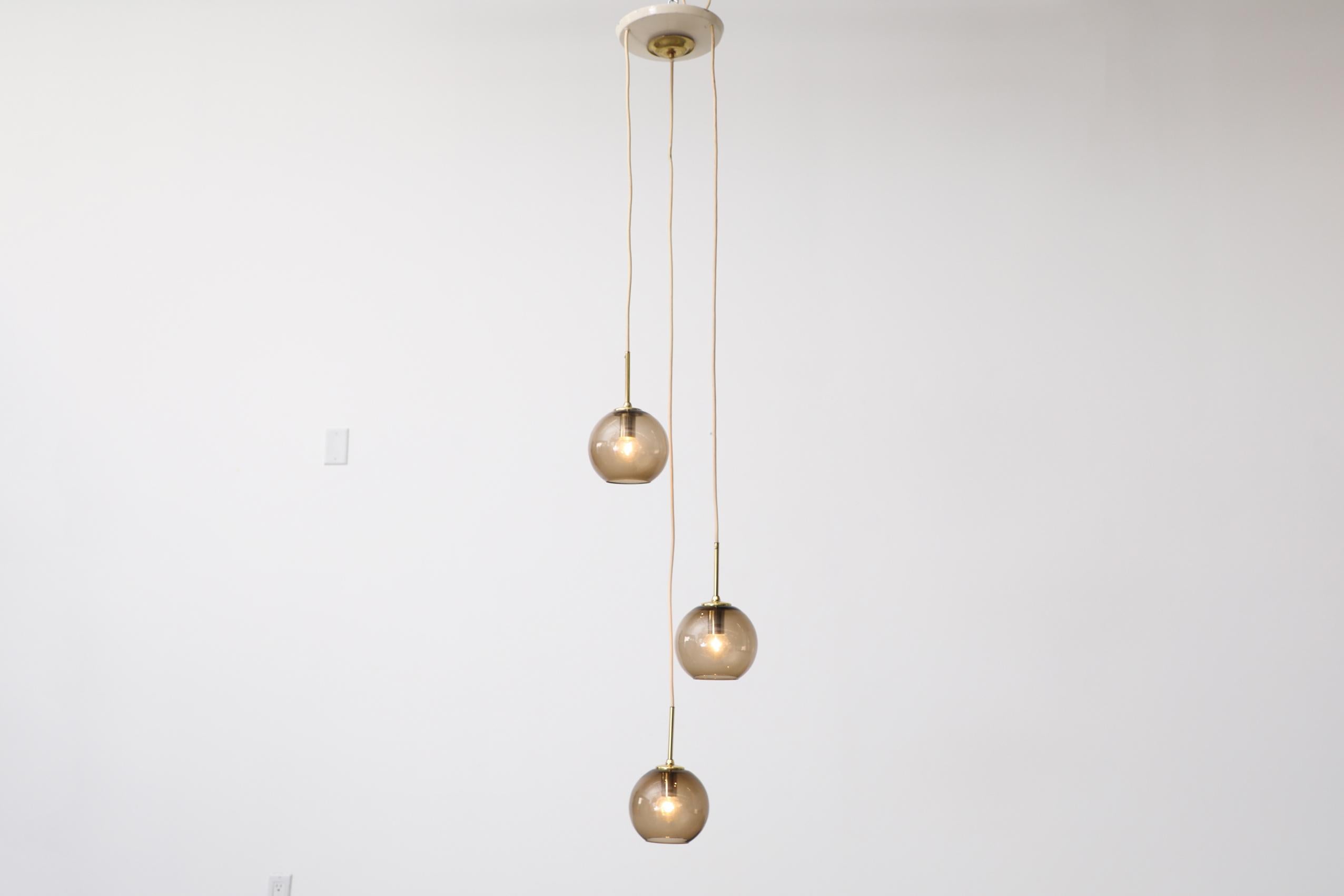 Mid-Century Modern 1970s Chandelier with 3 Smoked Glass Globes, Brass Hardware and Triple Canopy For Sale