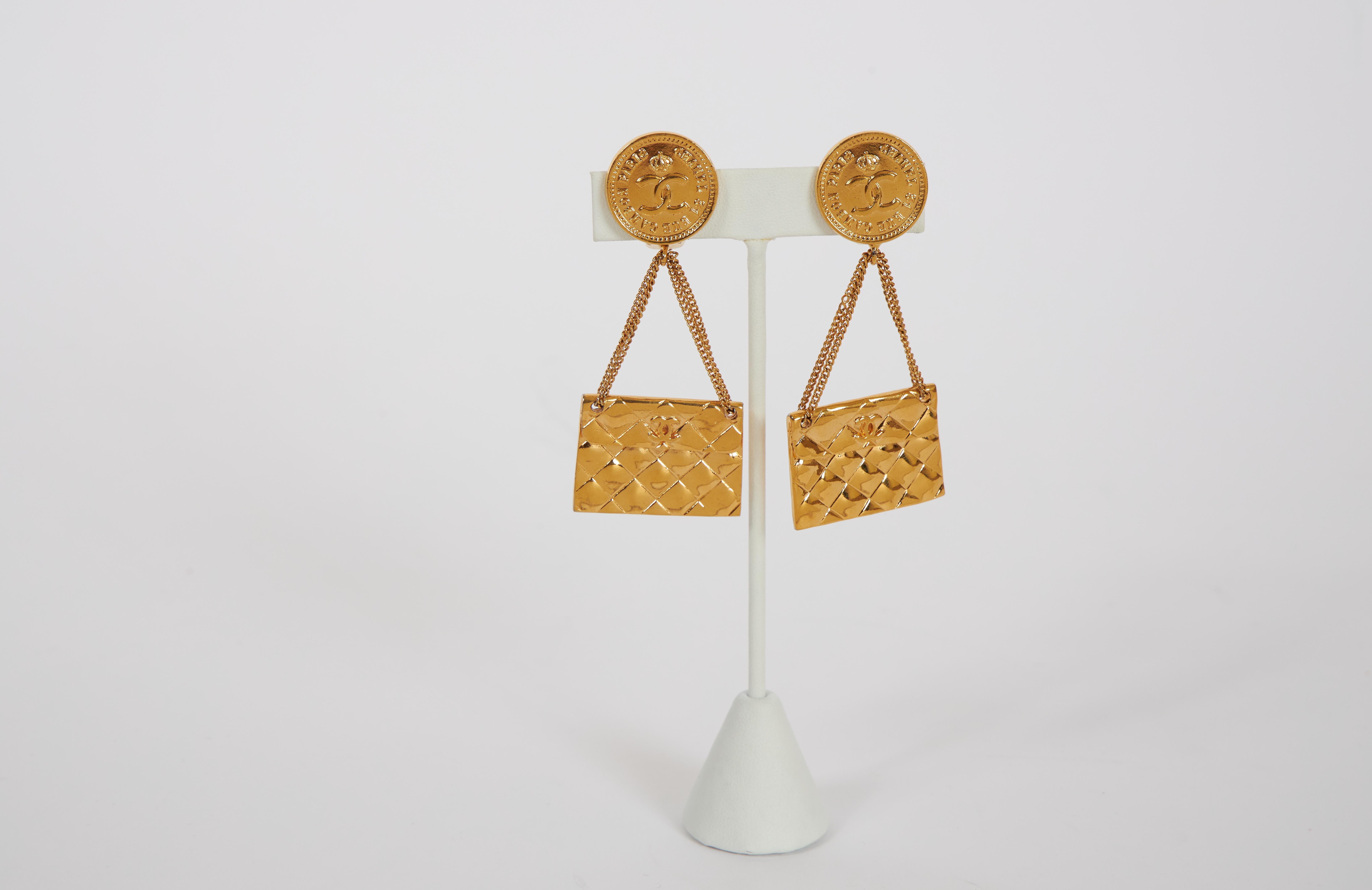 1970s Chanel goldtone metal earrings with drops inspired by the brand's iconic flap bag. Clip backs. Original box included.