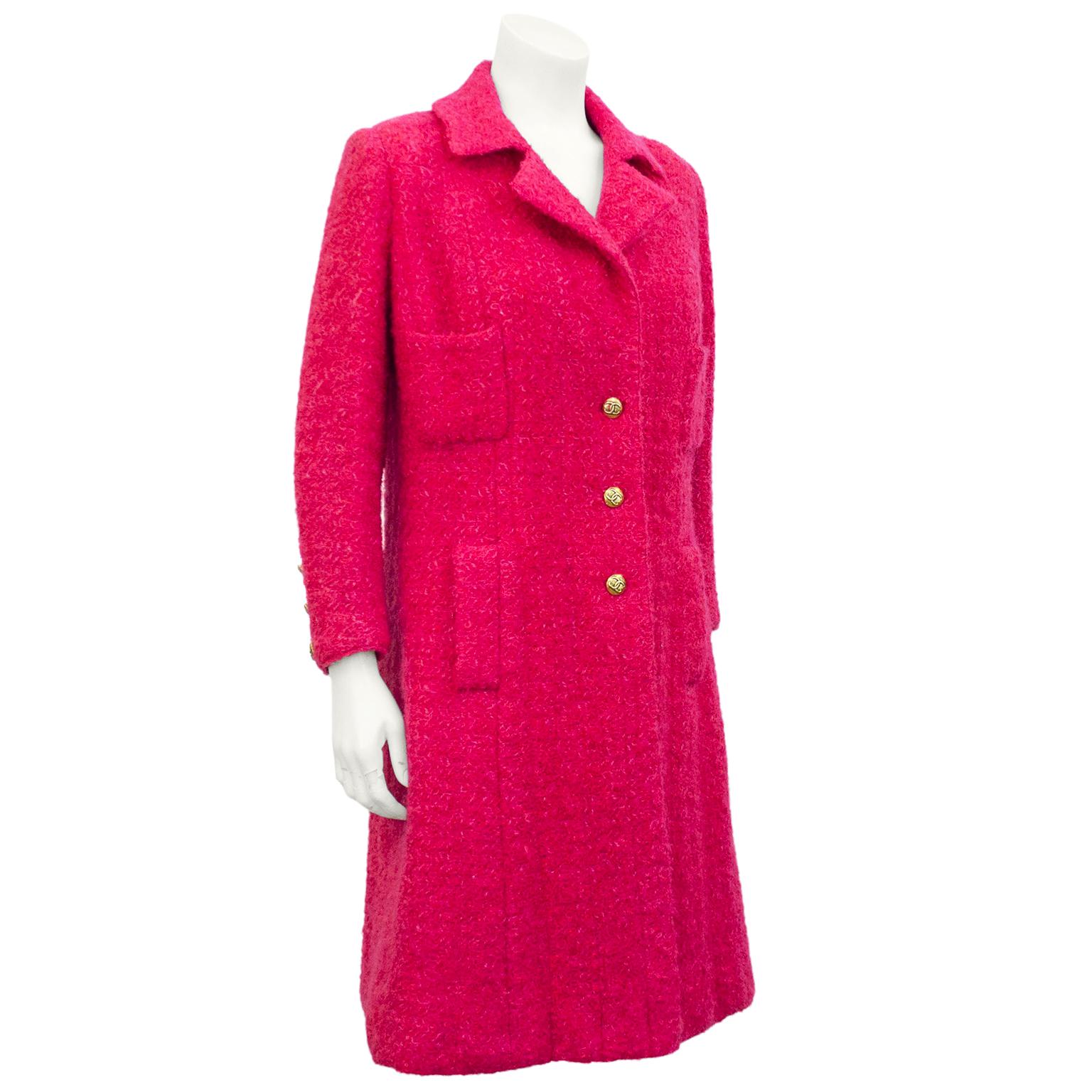 Superb raspberry wool bouclé Chanel haute couture coat dress from the mid 1970's. Single breasted classic silhouette with 2 patch pockets on the upper bodice and 2 hip pockets with flanges. Fully lined in matching silk with gold link chain at the