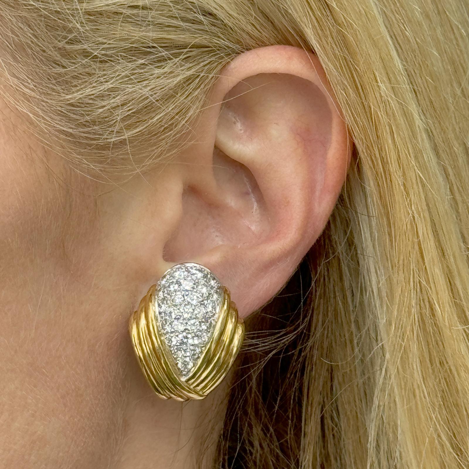 The Charles Turi Diamond Earrings are a captivating vintage piece. These earrings feature an elegant ribbed design in luxurious 18 karat yellow gold, accentuated by 52 round brilliant sparkling diamonds. The diamonds weigh approximately 3.50 carat