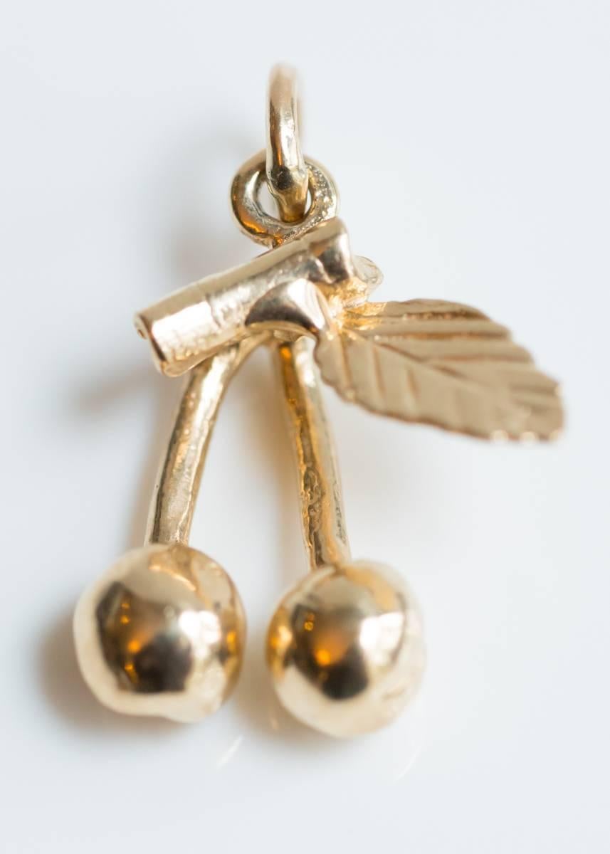 1970s Cherries Pendant Charm 14 Karat Yellow Gold

Features 2 round cherries with stems, a variegated leaf and a short stem. Crafted from 14 Karat Yellow Gold, this charm shines with a high polish. This charm is a great way to remember summer,