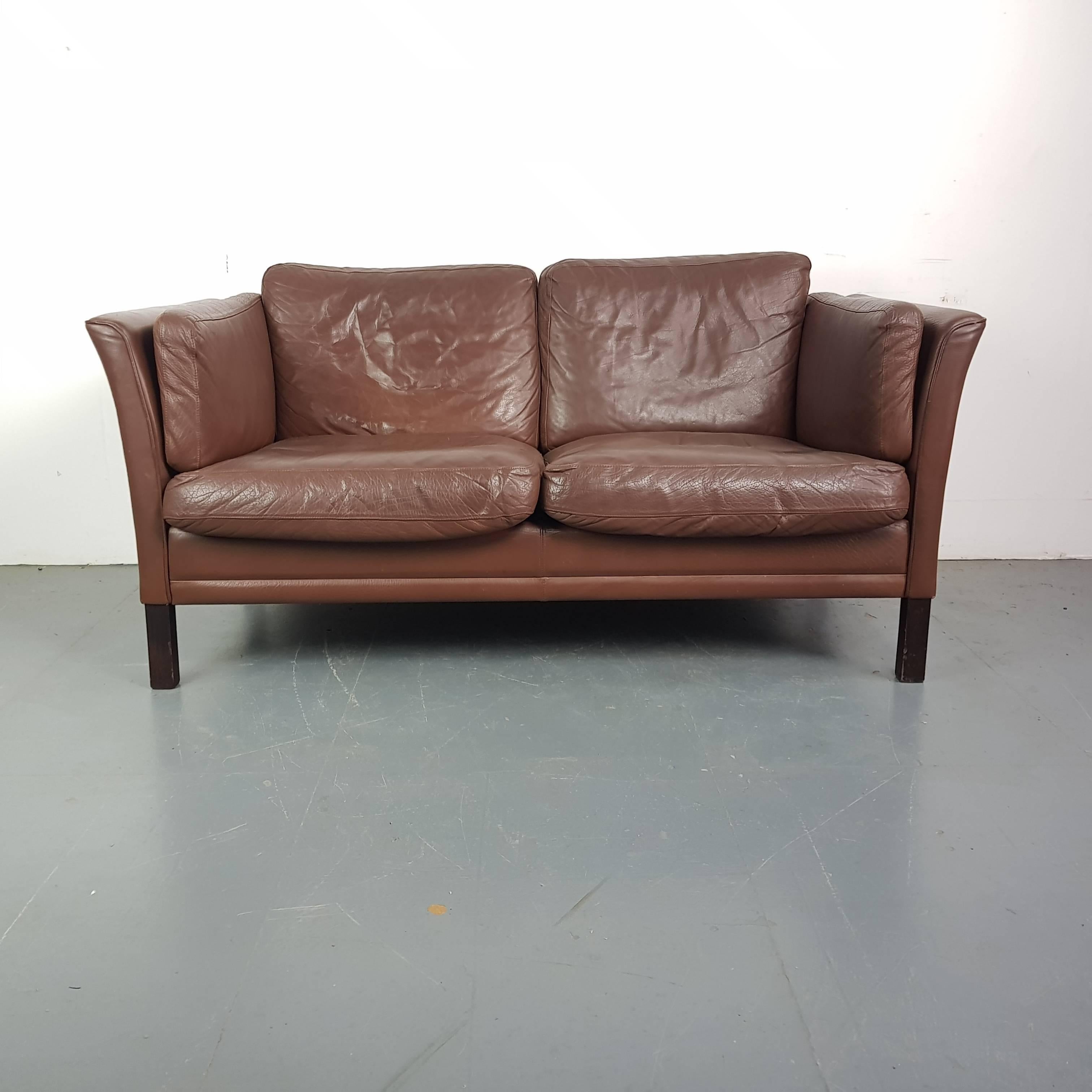 Chestnut brown leather Mogensen style 1970s two-seat sofa. 

Detachable down-filled seat cushions. Wooden legs.

Approximate dimensions:

Width 153cm

Depth 80cm

Height 76cm.

In good vintage condition; some wear and tear, a few bumps