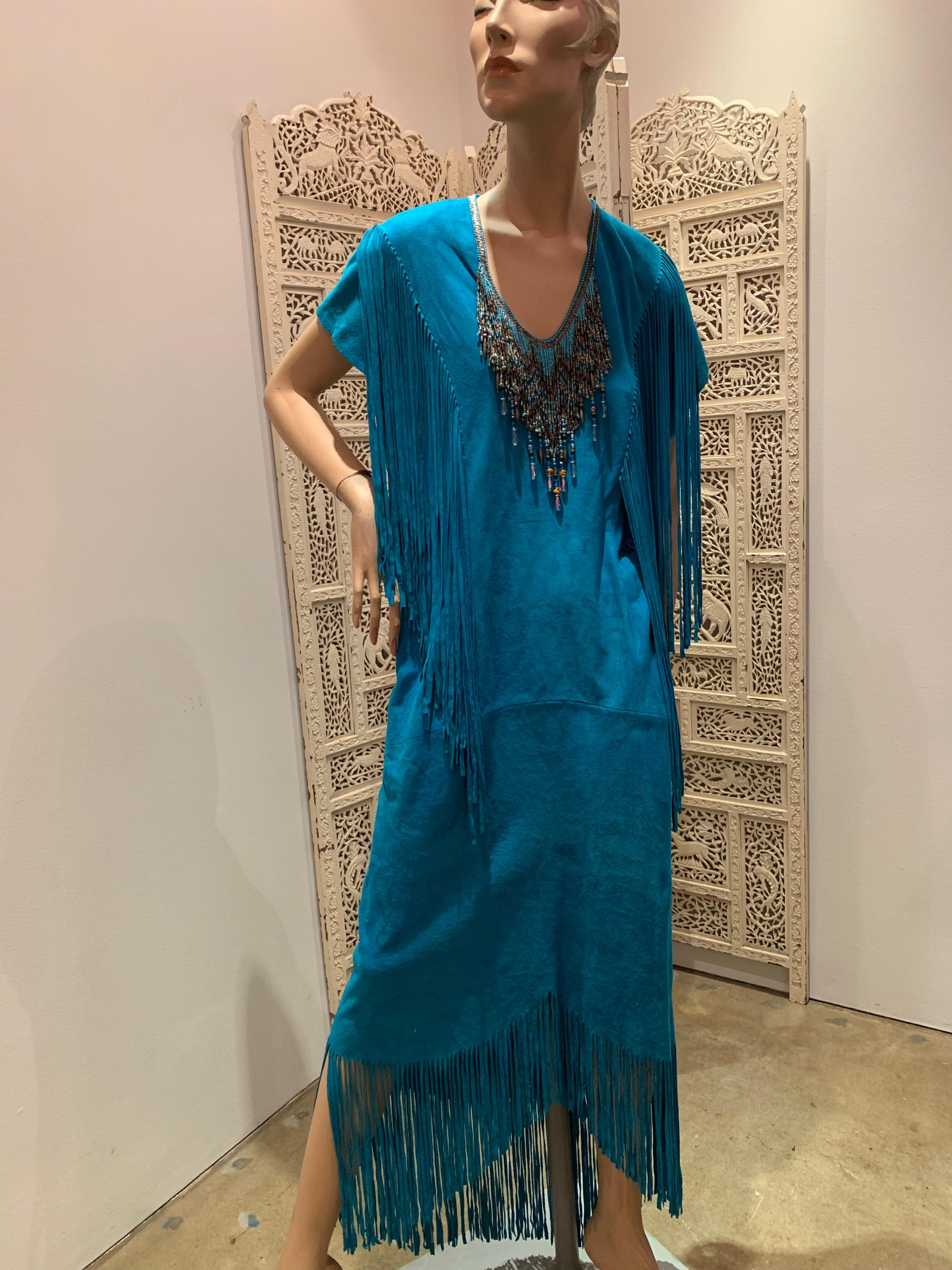 A sexy 1970s Chic Skins of California turquoise doeskin suede caftan with cut suede fringe at hem and shoulders and heavy glass beaded Native American-inspired fringe at neckline. 