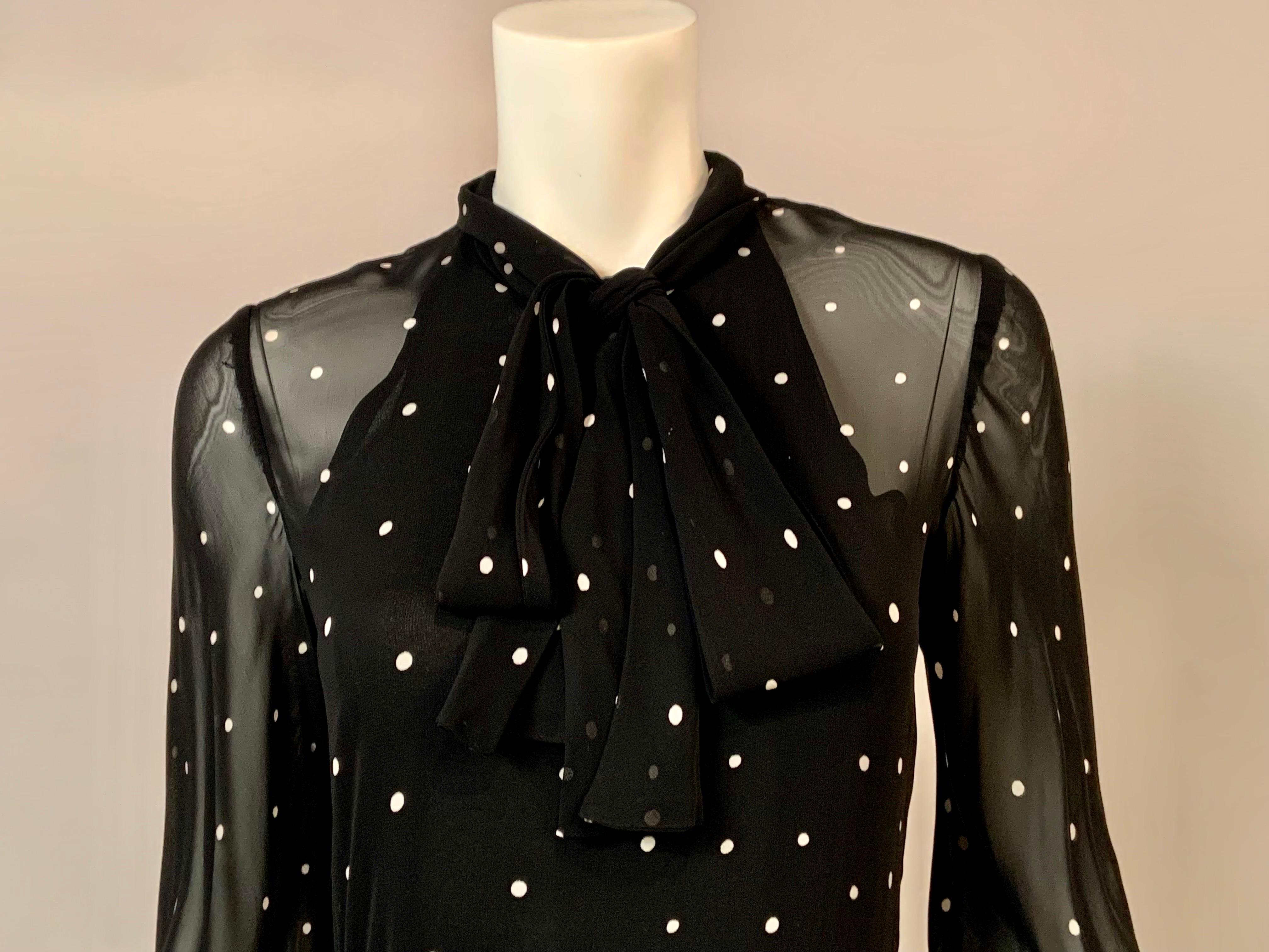This is such a fun maxi dress from the 1970's.  The top black chiffon with white polka dots. It has a high neckline with a pussy cat bow and long sleeves with a button cuff.  The skirt is a coordinating print with white polka dots and a floral