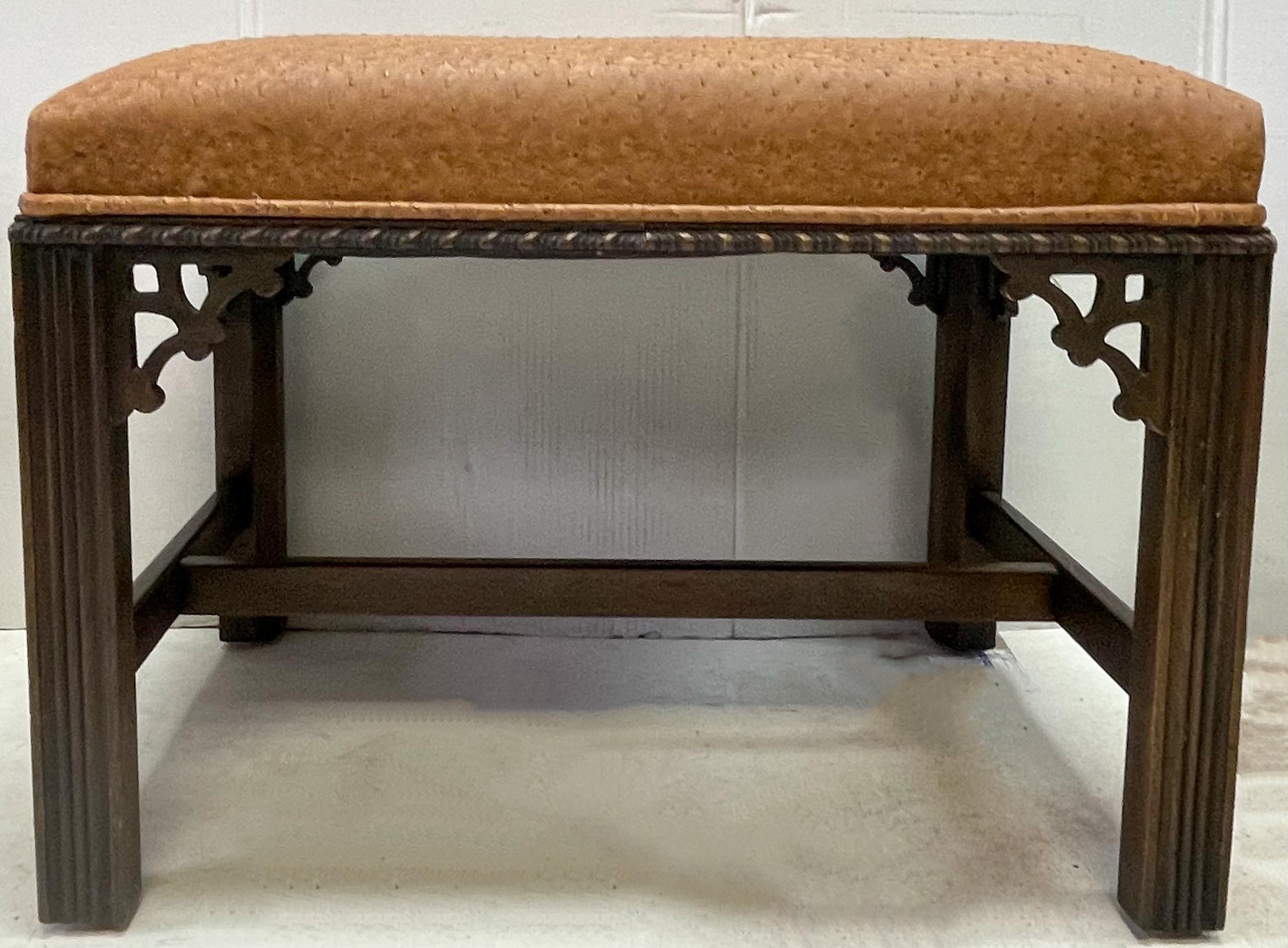 This is a handsome pair of Chinese chippendale style carved mahogany benches with ostrich leather upholstery. Both are in very good condition. They are unmarked.