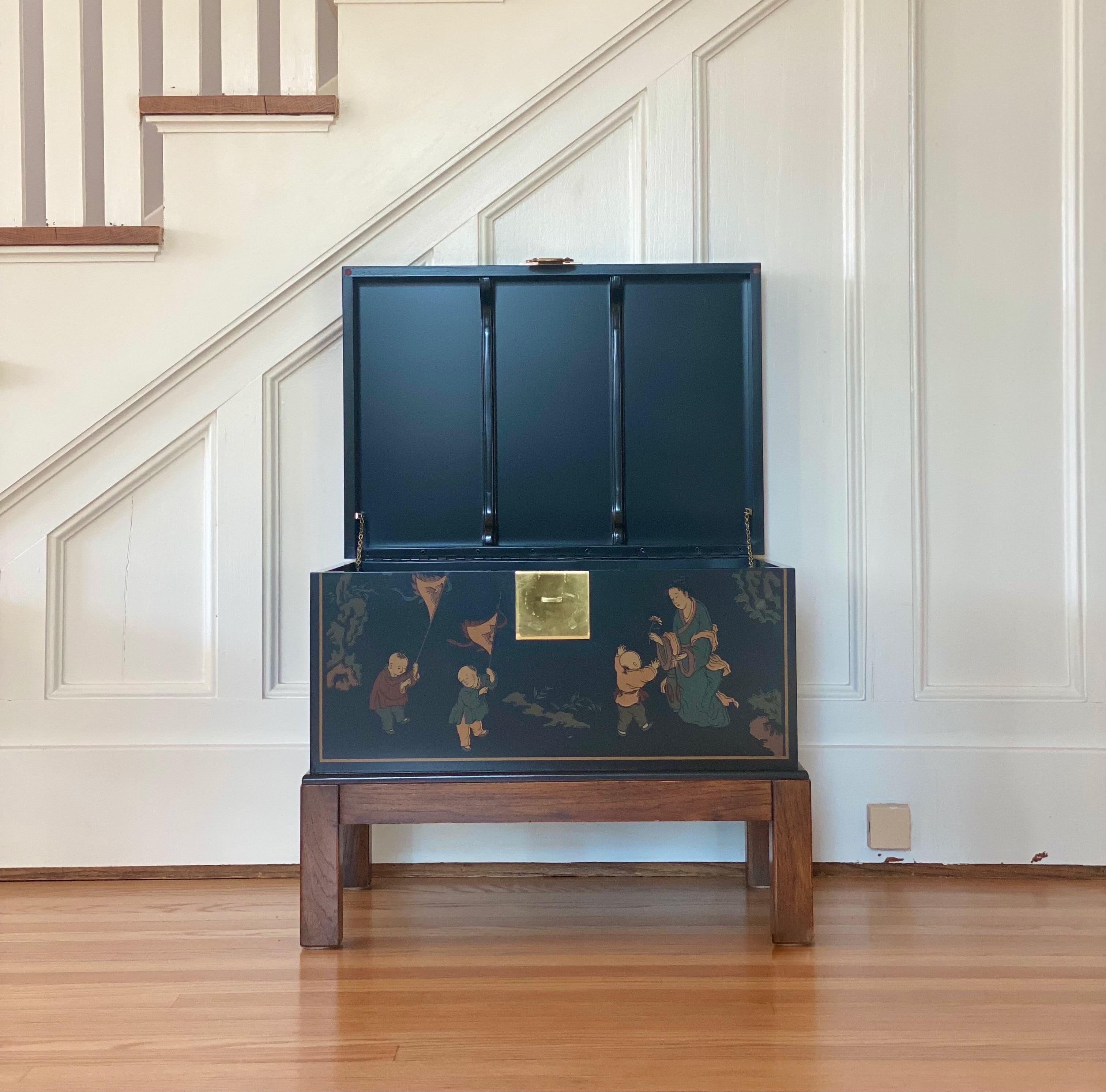 We are very pleased to offer a stunning Chinoiserie chest, circa the 1950s. Crafted of solid hardwood and finished in a rich black lacquer, this beautiful piece boasts ample storage and style. It’s artfully finished with hand painted images of