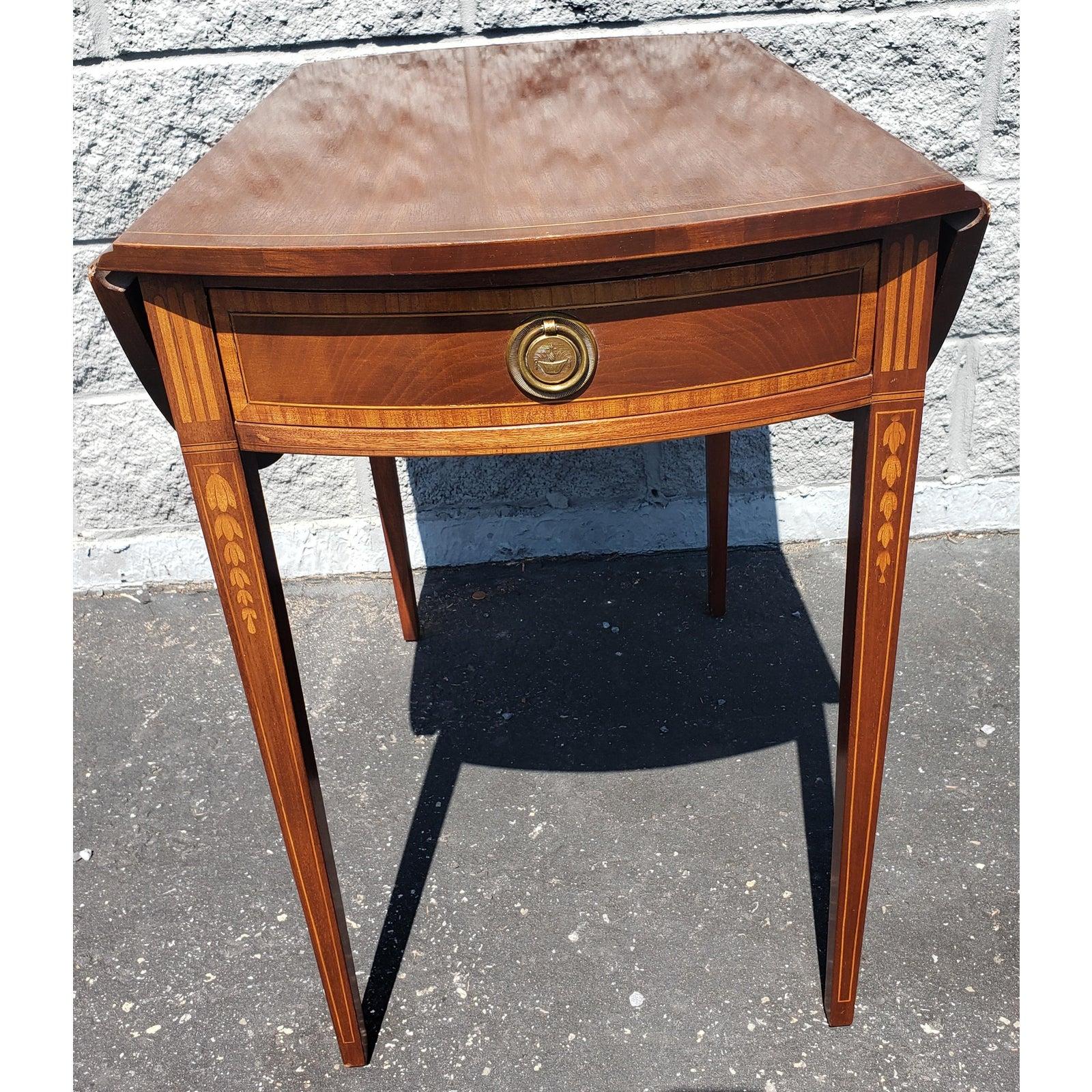 Inlaid mahogany and satin wood drop leaf pembroke side table. Height: 27.88 Inches; Width: 21.5 Inches; Depth: 39.75 Inches. A gorgeous Sheraton style Pembroke nightstand or end table
USA, Circa 1970s. Mahogany, with satinwood inlay and original