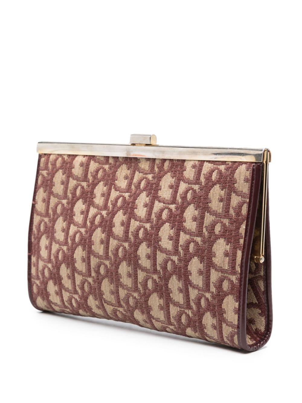 Christian Dior bordeaux Oblique clutch bag featuring  a canvas monogram Oblique logo, a top metallic claps opening, an inside bordeaux leather lining, an inside gold tone logo stamp. 
Circa: 1970s
Length 8.6in. (22 cm)
Height 5.1in. (13cm)
Depth