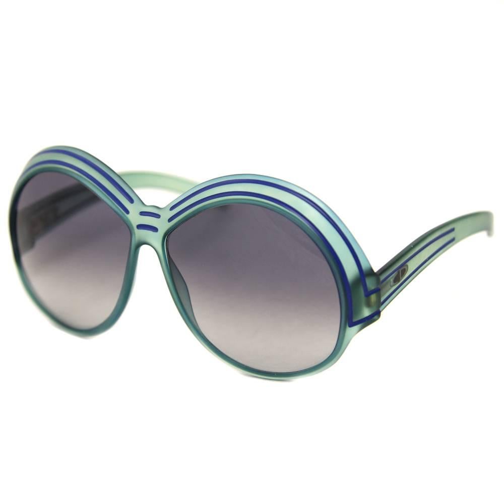 Super edgy Christian Dior bright blue sunglasses from the Seventies. The frame is opaque with two brilliant blue stripes on the temples. Good conditions.
Please note this item cannot be shipped to the US.

Measurements:
Width: 15 cm
Height: 7 cm