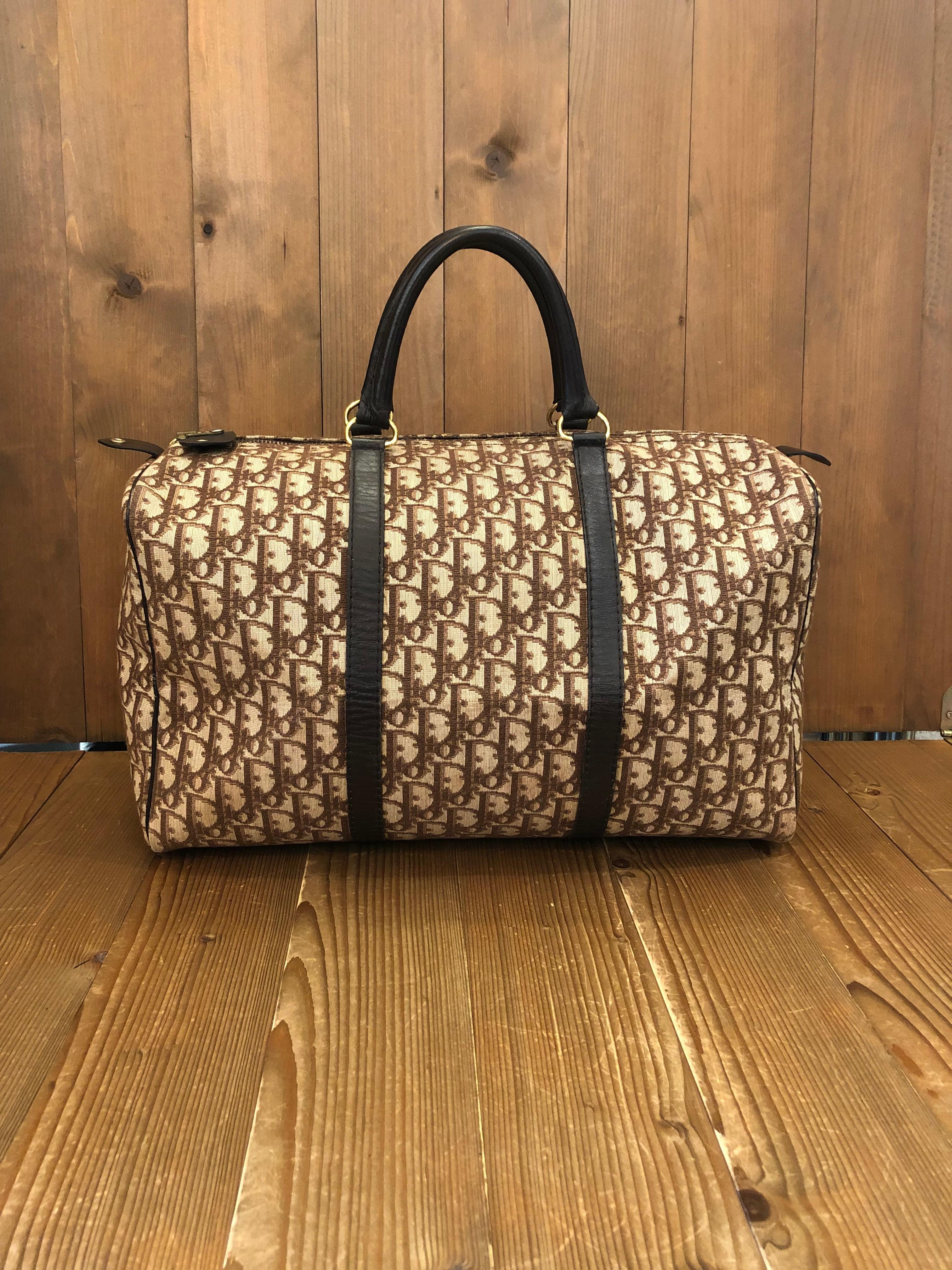 This vintage CHRISTIAN DIOR boston bag is crafted of iconic Dior Trotter jacquard in brown. Top zipper closure opens to a beige canvas interior with one zippered pocket. Made in France. Measures 15.75 x 10 x 7 inches handle drop 5