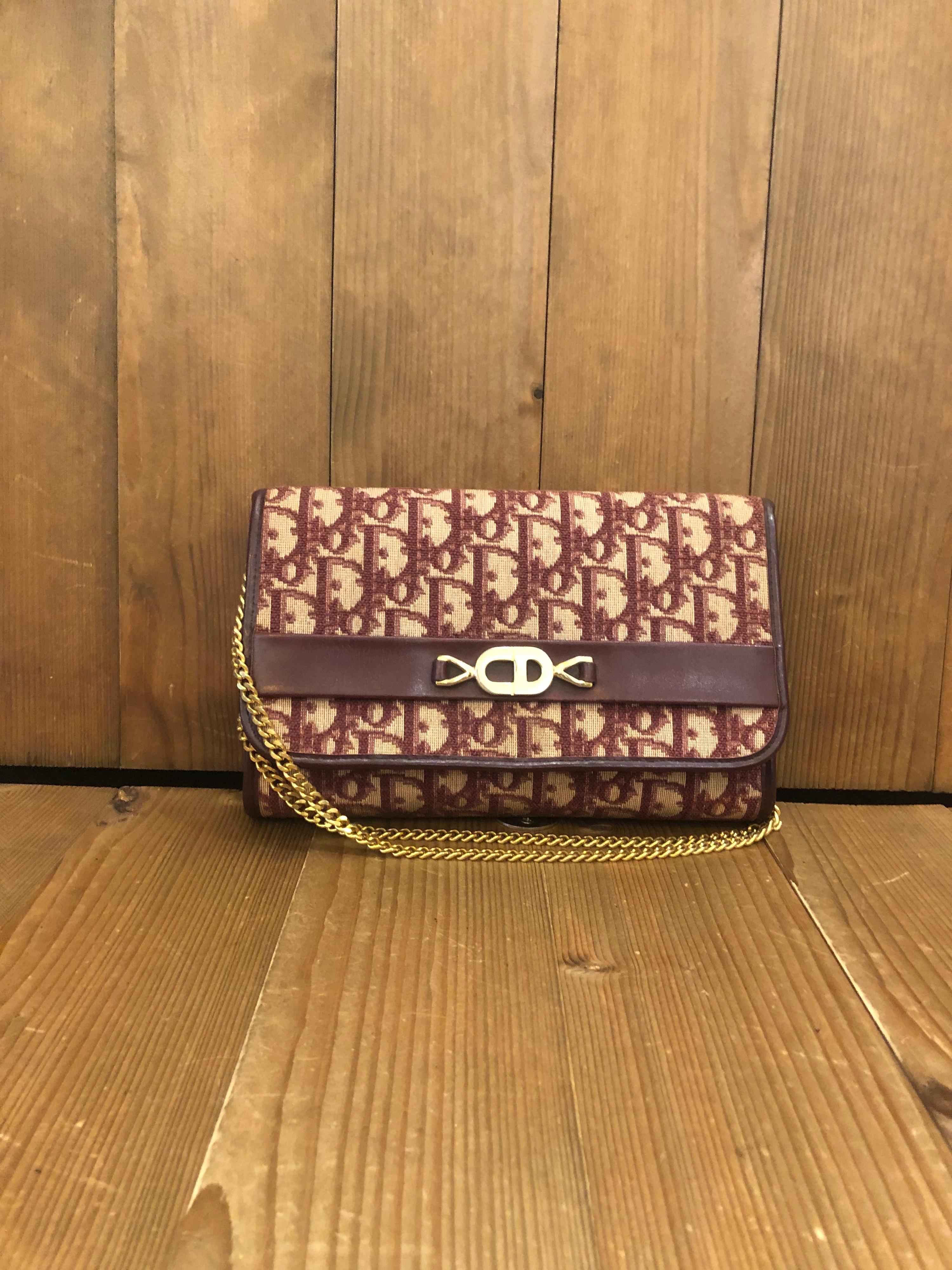 This vintage Christian Dior chain shoulder bag is crafted of Dior’s signature trotter jacquard in burgundy featuring gold toned hardware. Front flap magnetic snap closure opens to a coated interior in burgundy. Original fastening is replaced with