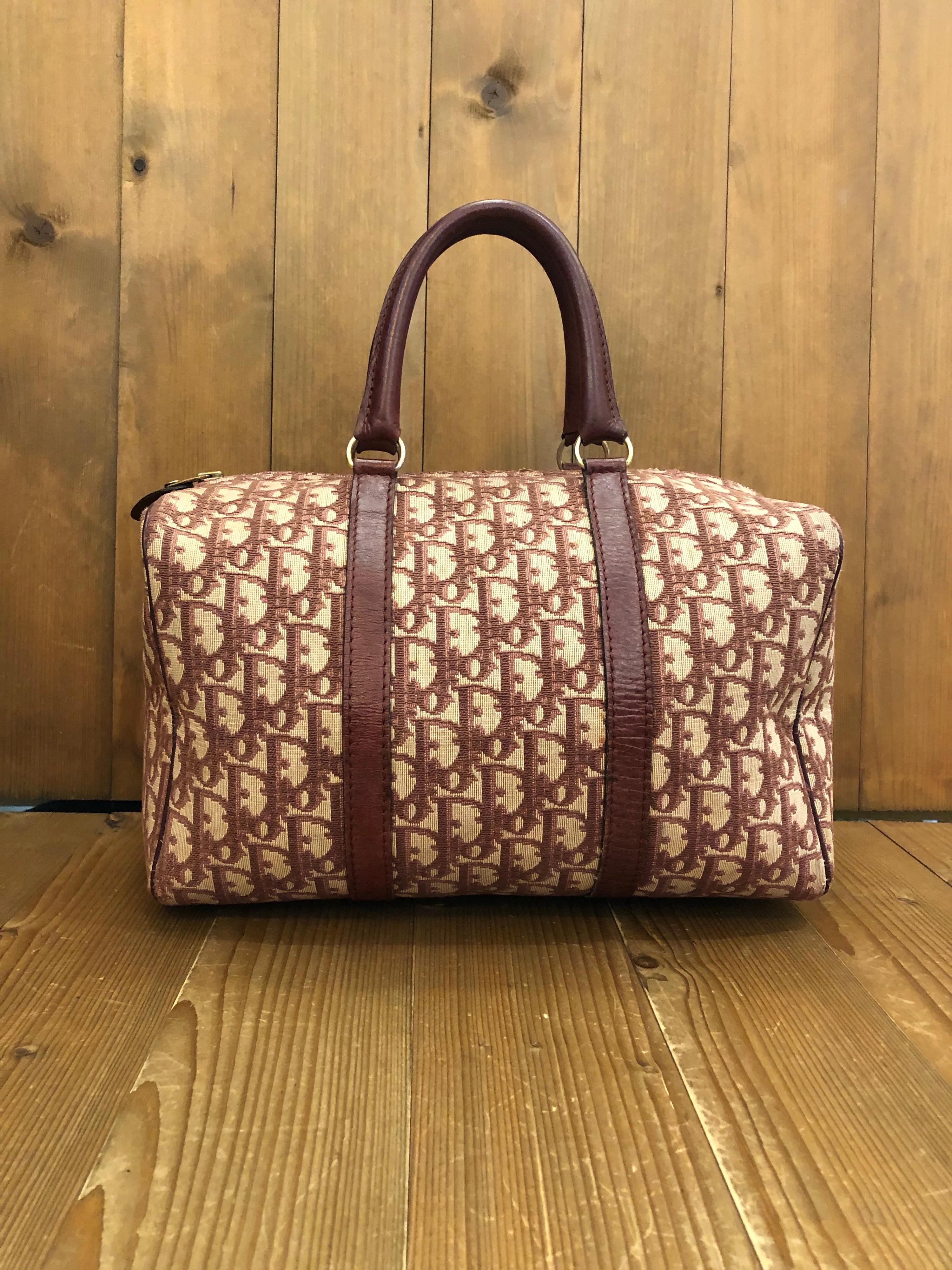 1970s CHRISTIAN DIOR Burgundy Trotter Jacquard Boston Bag 30
Material: Jacquard and leather
Color: Burgundy
Origin: France 
Measurements: 12”x7.5”x6.5”
Handle Drop. 5”
Specifications: 1 interior zip pocket 

Condition:
Outside: Minor marks on