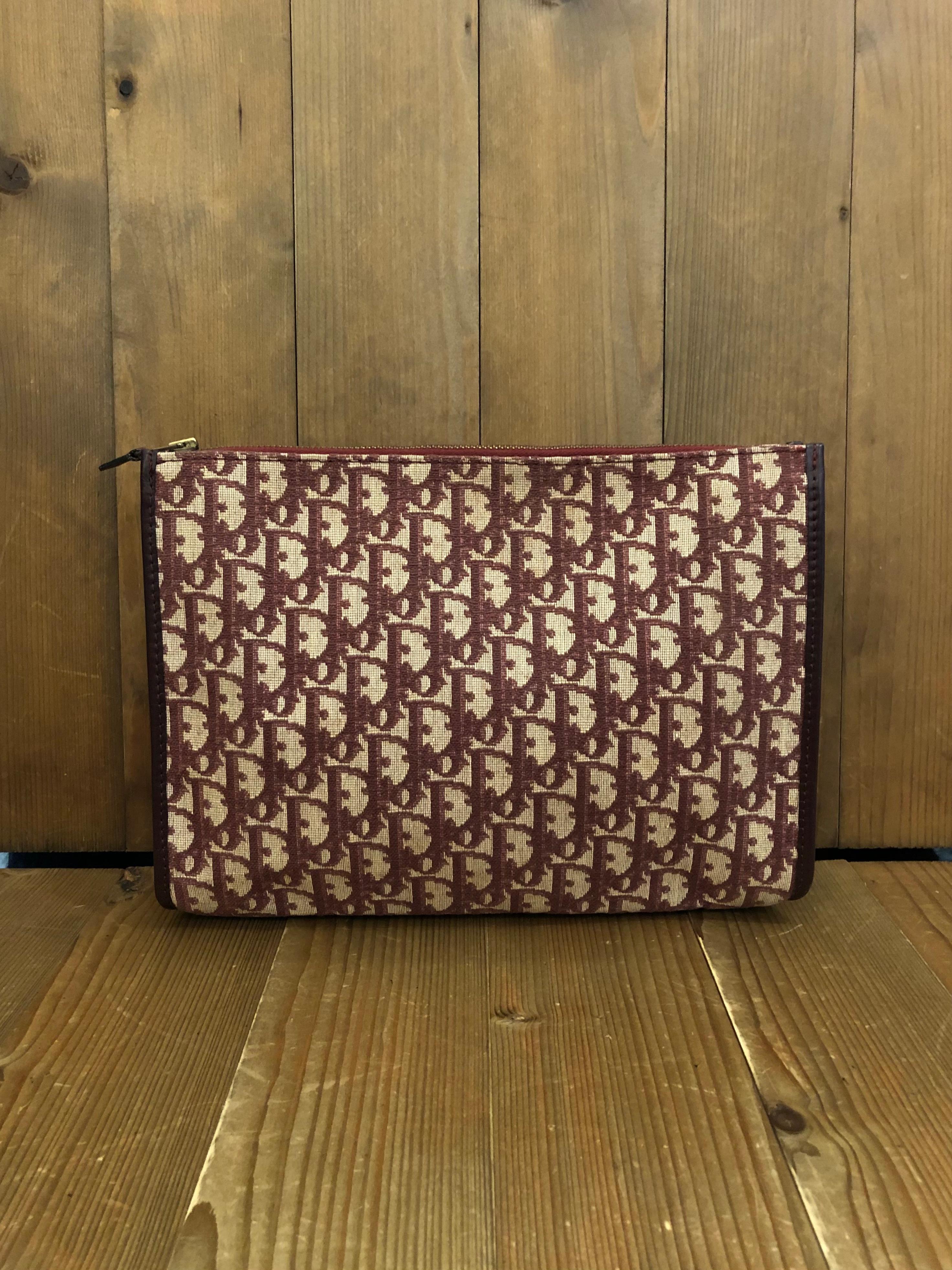 1970s CHRISTIAN DIOR large clutch bag in burgundy Trotter jacquard with leather trimmings. Made in France. Measures 11.75 x 9.5 x 3 inches. 

Condition: Minor marks on jacquard from old storage. Interior shows cracks throughout the surface due to