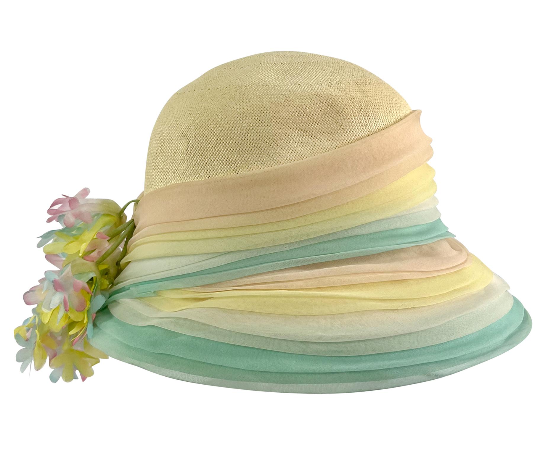 From the 1970s, this elegant tan woven raffia Christian Dior wide brim hat features a multicolor pleated accent around the brim and is complete with floral details that cascade down the back. 

Approximate measurements: 
Size - removed
Top Diameter: