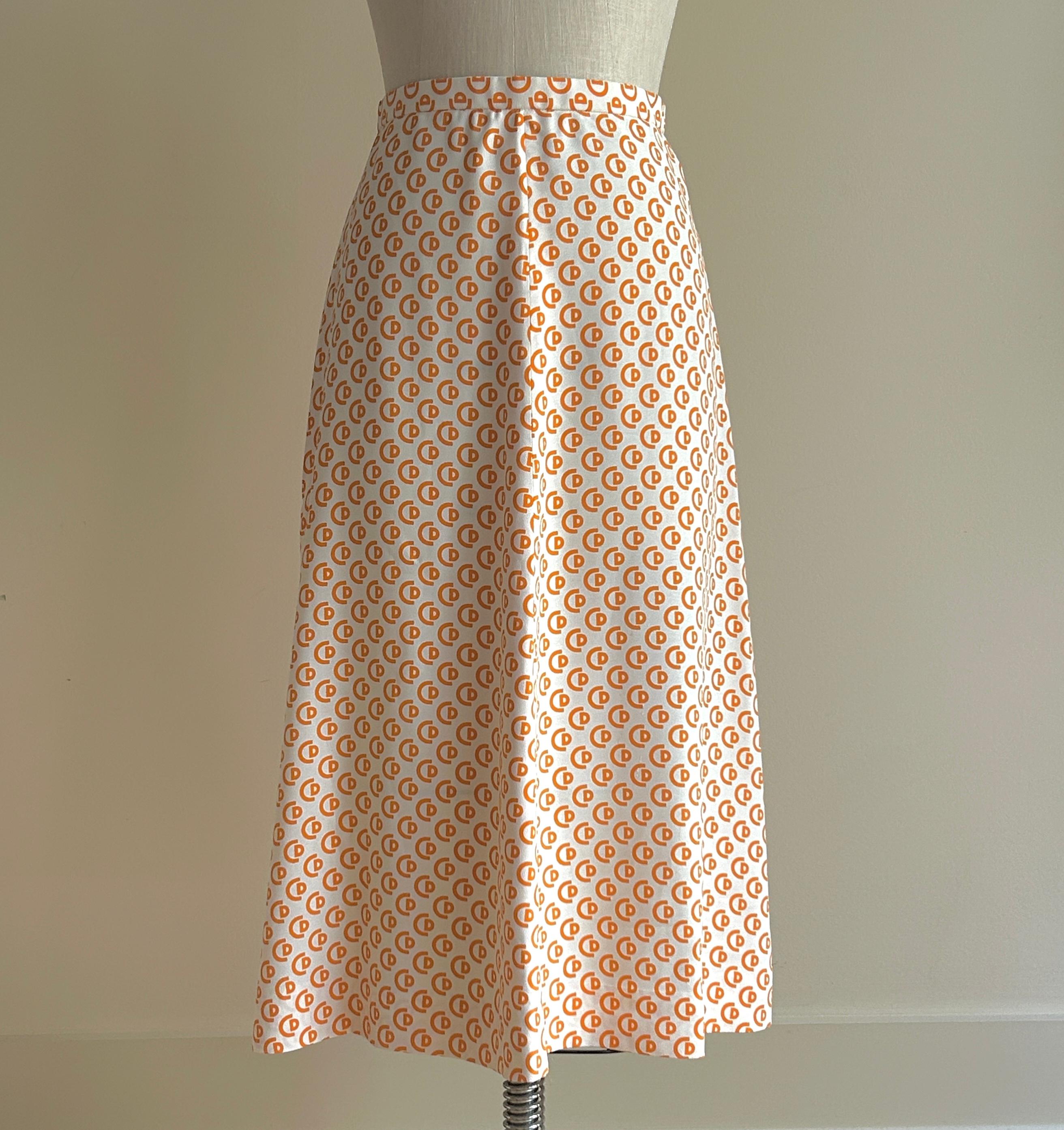 Christian Dior Paris 1970, gonna con logo CD bianca e arancione della linea Miss Dior. Tessuto leggero in una forma svasata/linea. Cerniera posteriore con chiusura a scatto e gancio. La linea Miss Dior è stata creata in Francia nel 1967 per servire