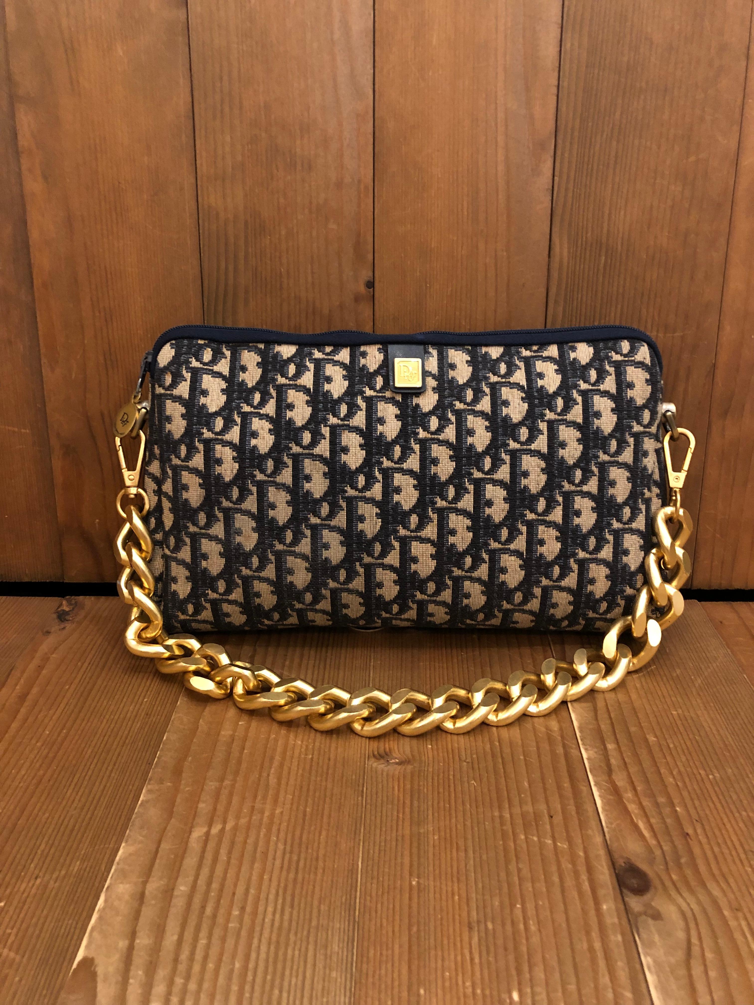 1970s CHRISTIAN DIOR Clutch Bag in navy Trotter jacquard with leather interior. Large in size. Made in France. Measures 10.25 x 6.5 x 1.75 inches. Third party non-Dior parts are added on each side to secure a gold toned chain. 

Condition: Some