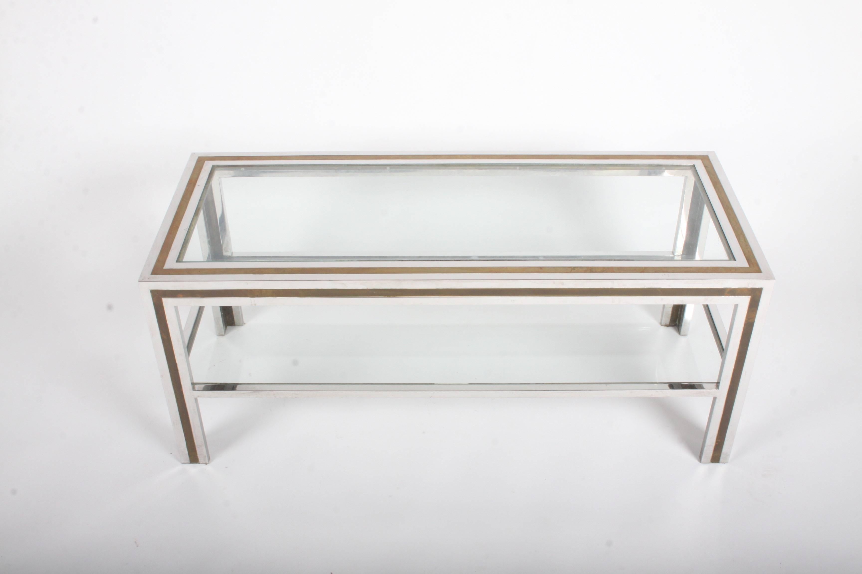 Vintage Italian 1970s chrome and brass two-tier coffee table. Minor scuffs to chrome and patina to brass, glass has light scratches. The two tone frame reminds me of Gucci's picture frames from the late 1970s and early 1980s. Lower shelf is 8.75