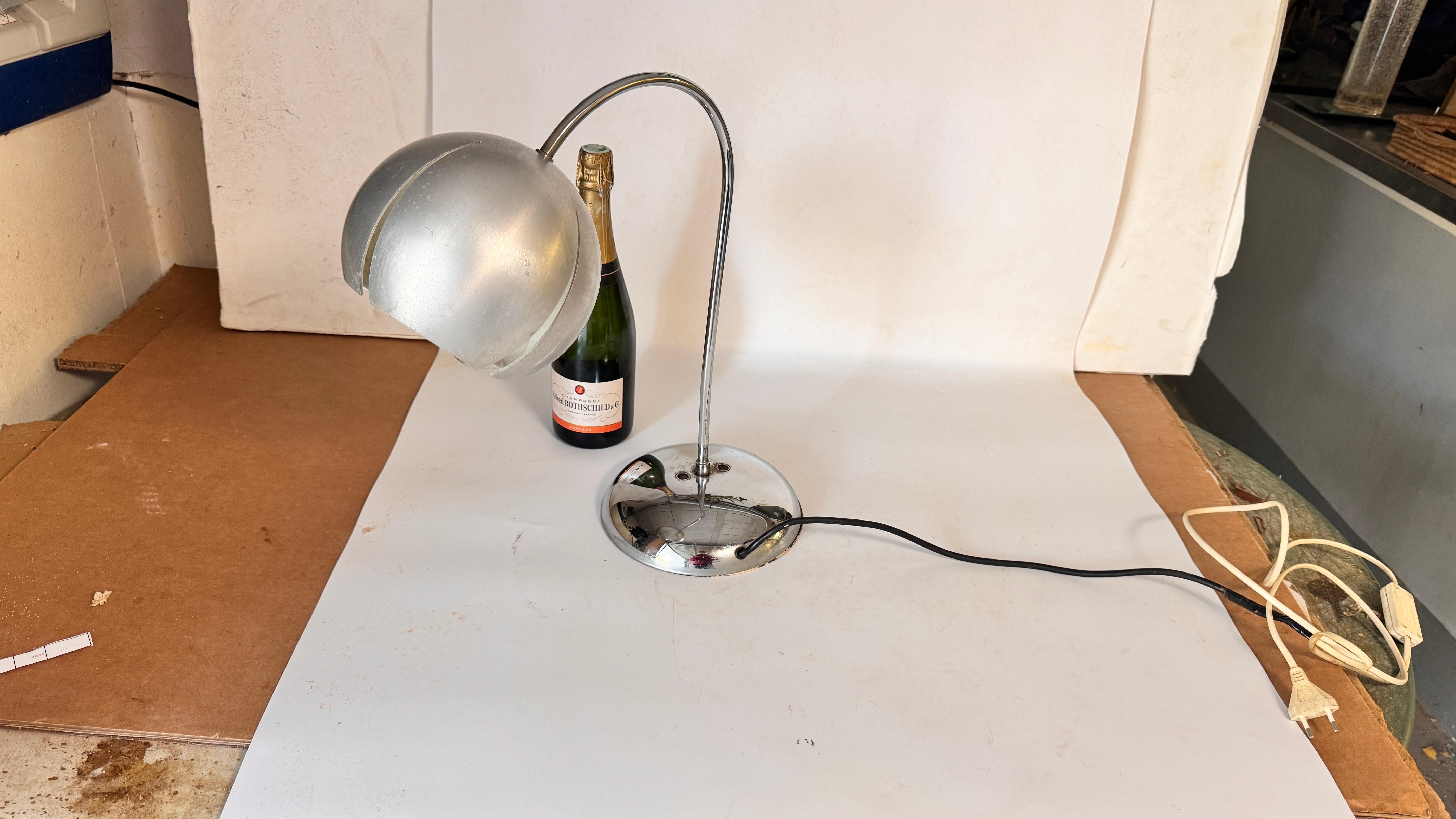 1970s Chrome and Aluminum Table Lamp – Curved Modernist French Design

Description:
This elegant table lamp from the 1970s combines chrome and aluminum in a sleek, modernist design. The rounded aluminum base, curved stem, and circular lampshade