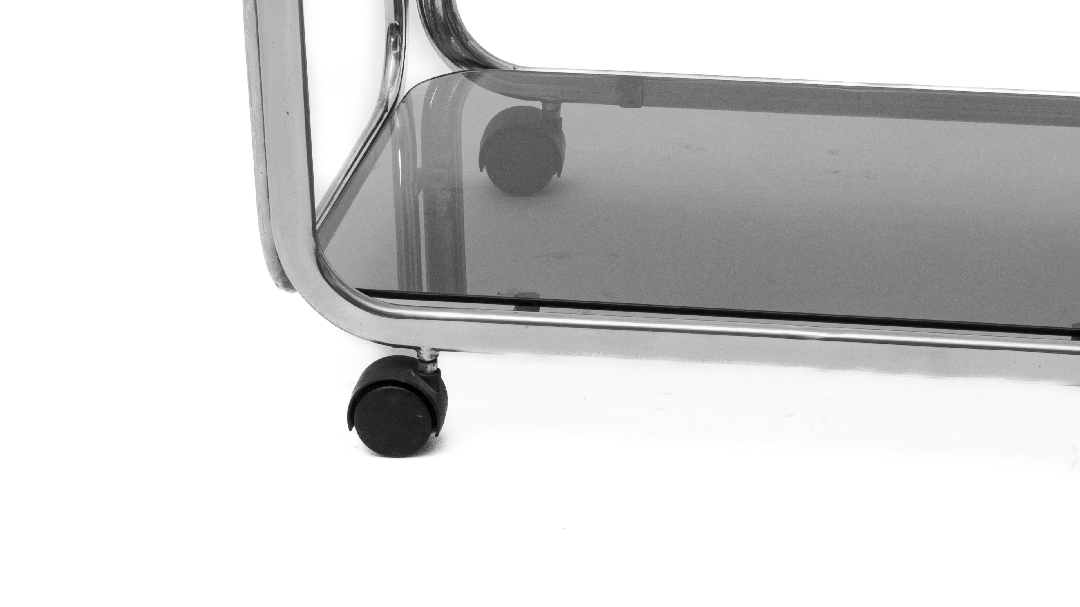 This vintage coffee table from the Space Age era blends functionality with modern design. The chrome frame supports two smoked glass tops. With wheels on the bottom, the table is easy to move, making it a versatile piece of furniture.
Its