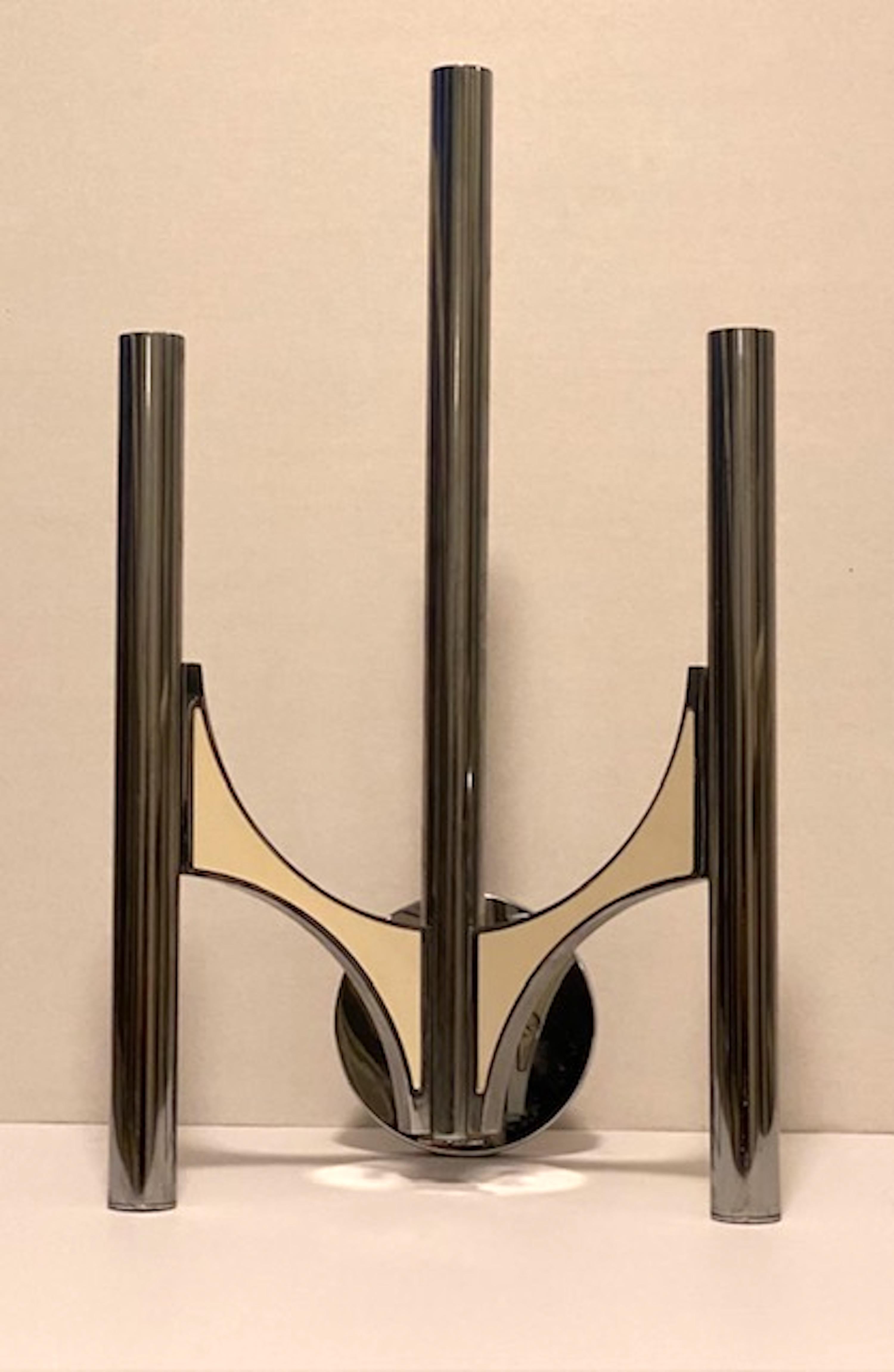 Interessanter dreiarmiger Wandleuchter von Gaetano Sciolari,  jedes Rohr enthält eine  Kandelaberglühbirne und Metallplatten an den Armen. Die emaillierten Metallplatten halten sich gegenseitig mit Magneten.
Der originale Sciolari-Aufkleber ist noch
