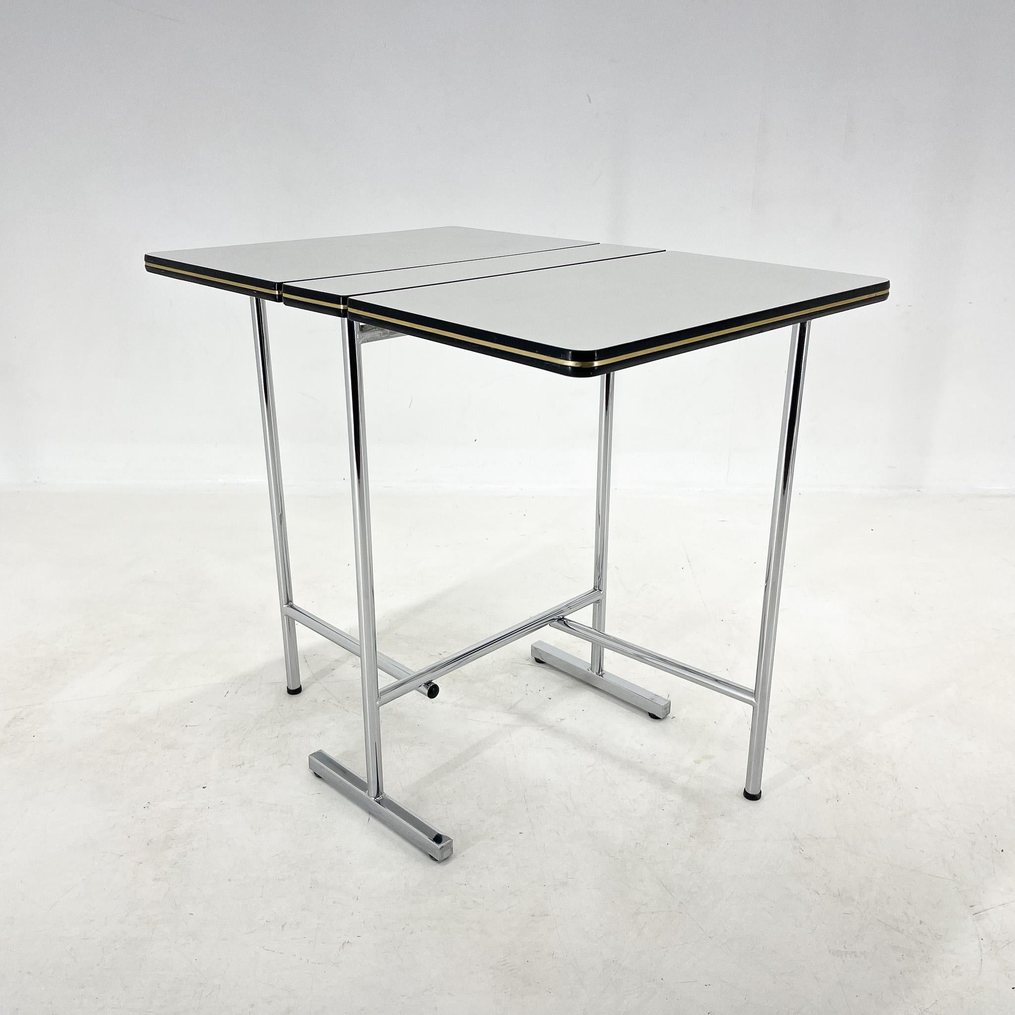 Vintage formica and chrome folding table. The chrome parts are in very good condition. The table is very easily foldable from both sides. The formica top has black edges with a golden coloured stripe decor.