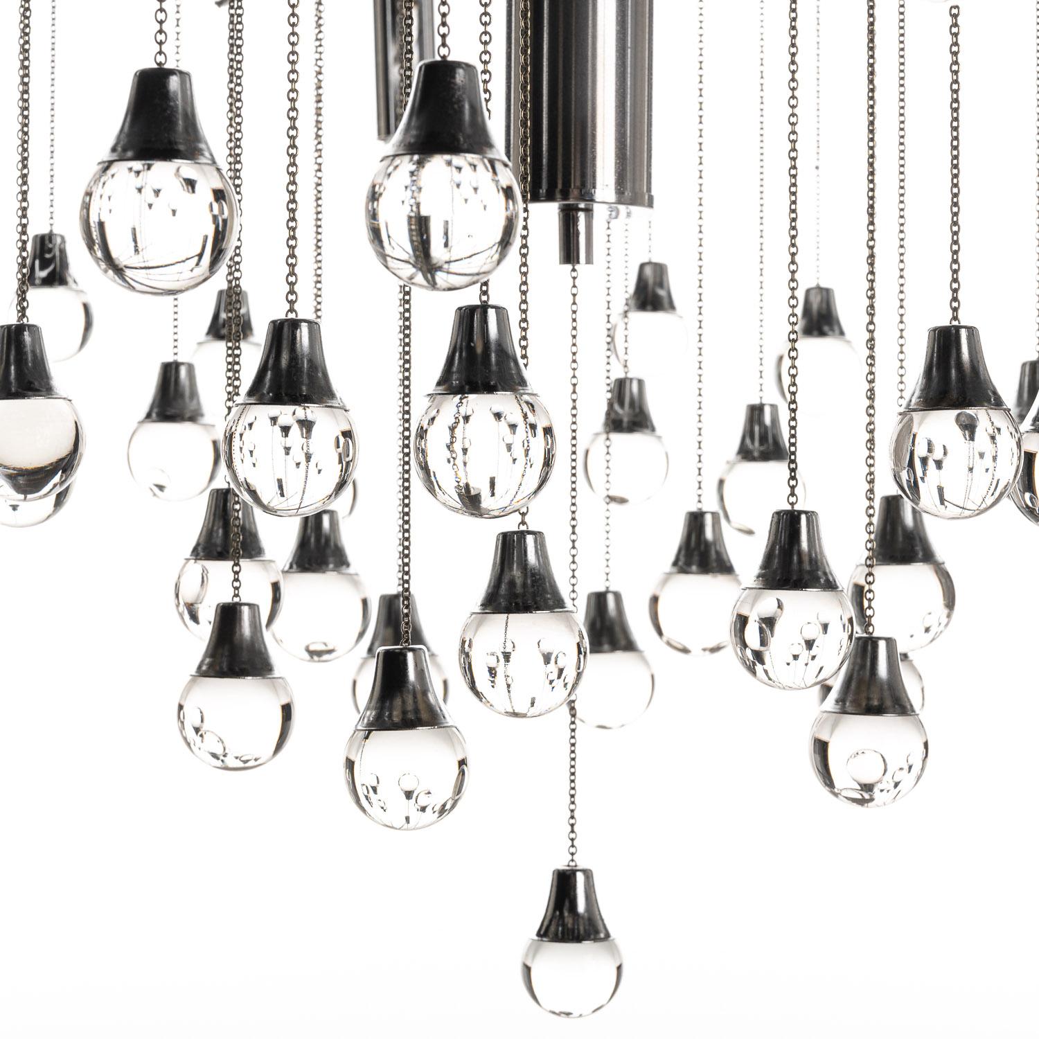 This is a stunning example of a Gaetano Sciolari pendant lamp from the 1970s. Six E14 bulbs radiate from a polished chrome base to give a modern feel.
     