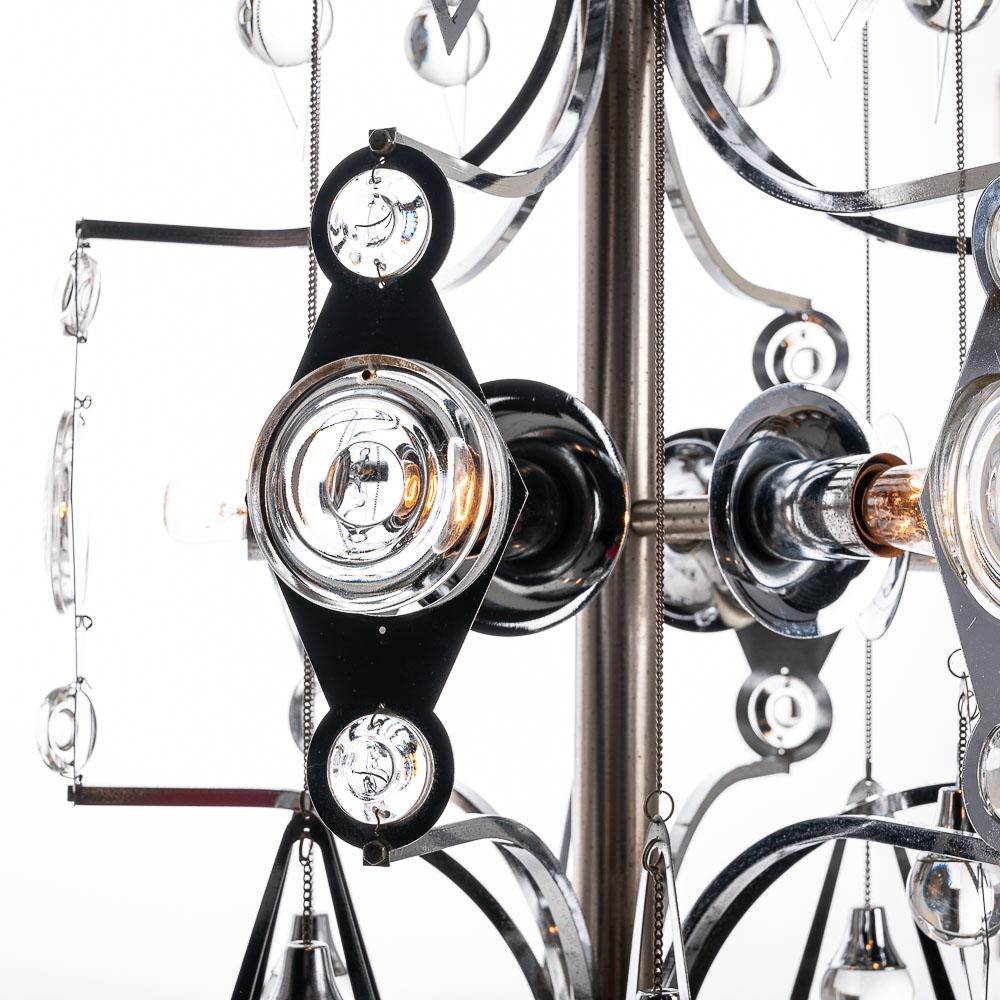 This is a beautiful chrome and glass piece from designer Gaetano Sciolari. It embraces elegant curvature to give a feeling of harmony and flow throughtout the design. The chrome, the decorative glass baubles, hanging chains and six bulbs beautifully