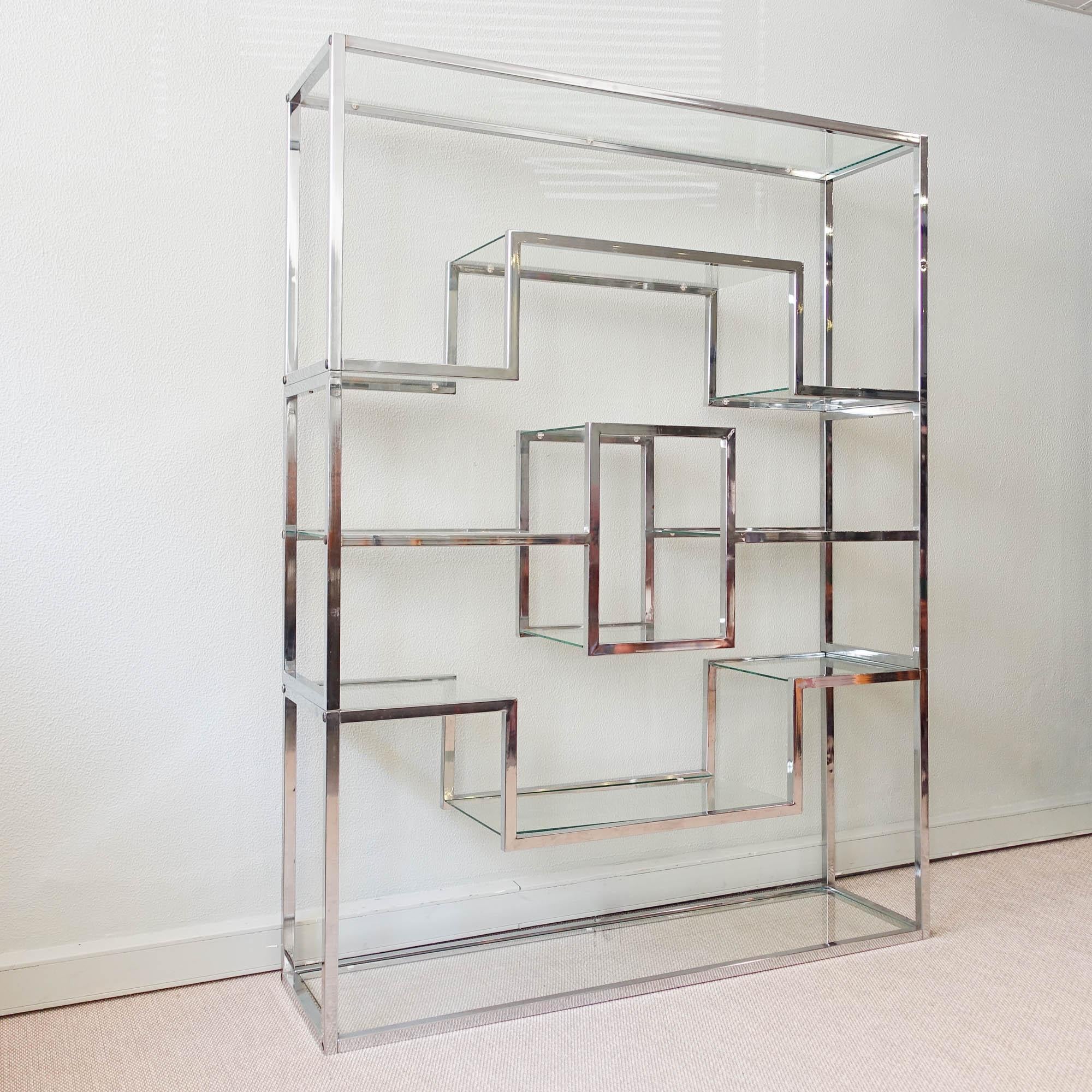Cette étagère a été conçue dans le style de Romeo Rega, en Italie, dans les années 1970. Chacune des cinq étagères supporte une plaque de verre transparent qui est maintenue en place par de petits supports en plastique. Son design épuré et